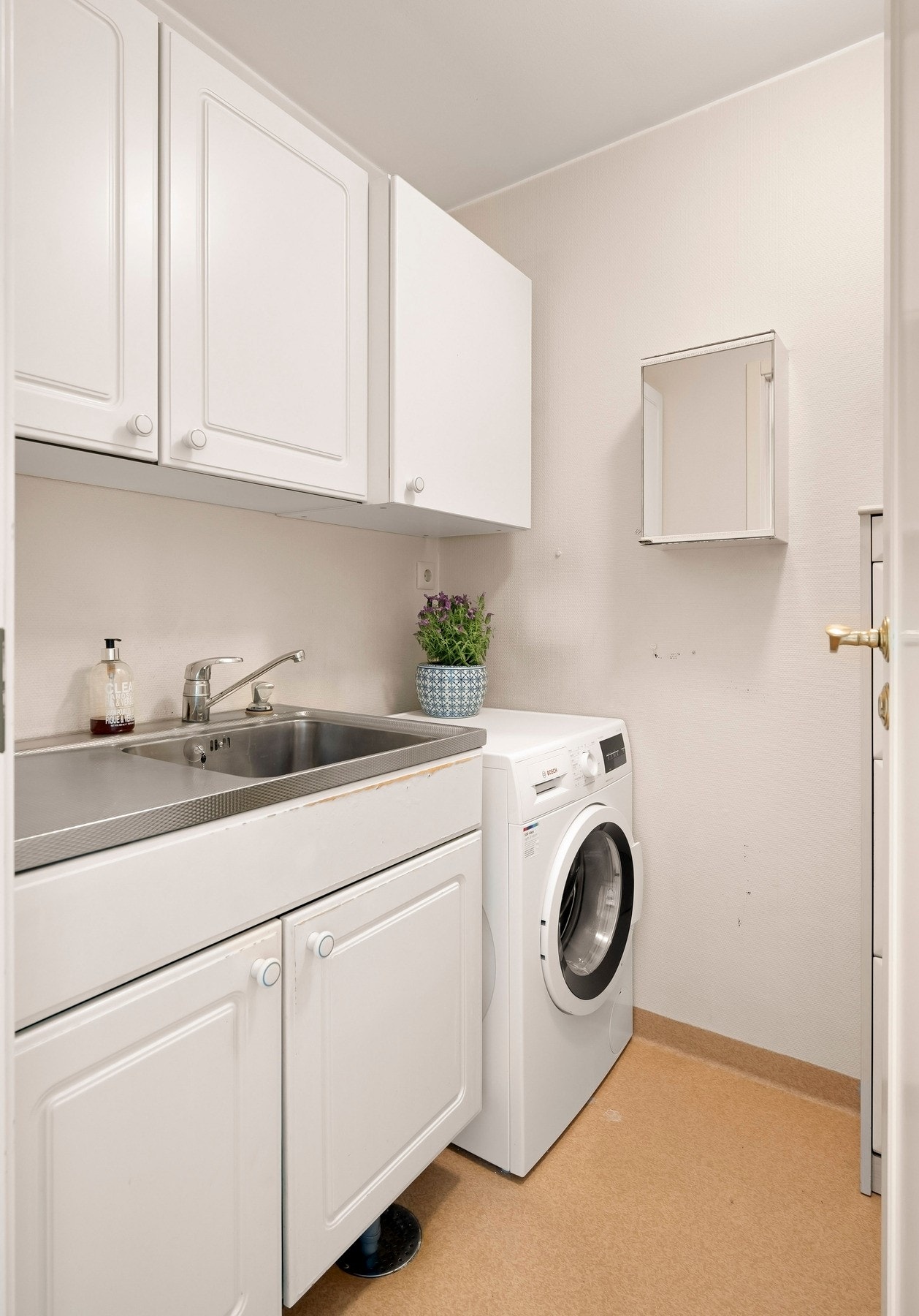 Vegg i vegg med badet har leiligheten et eget vaskerom. Galleribilde