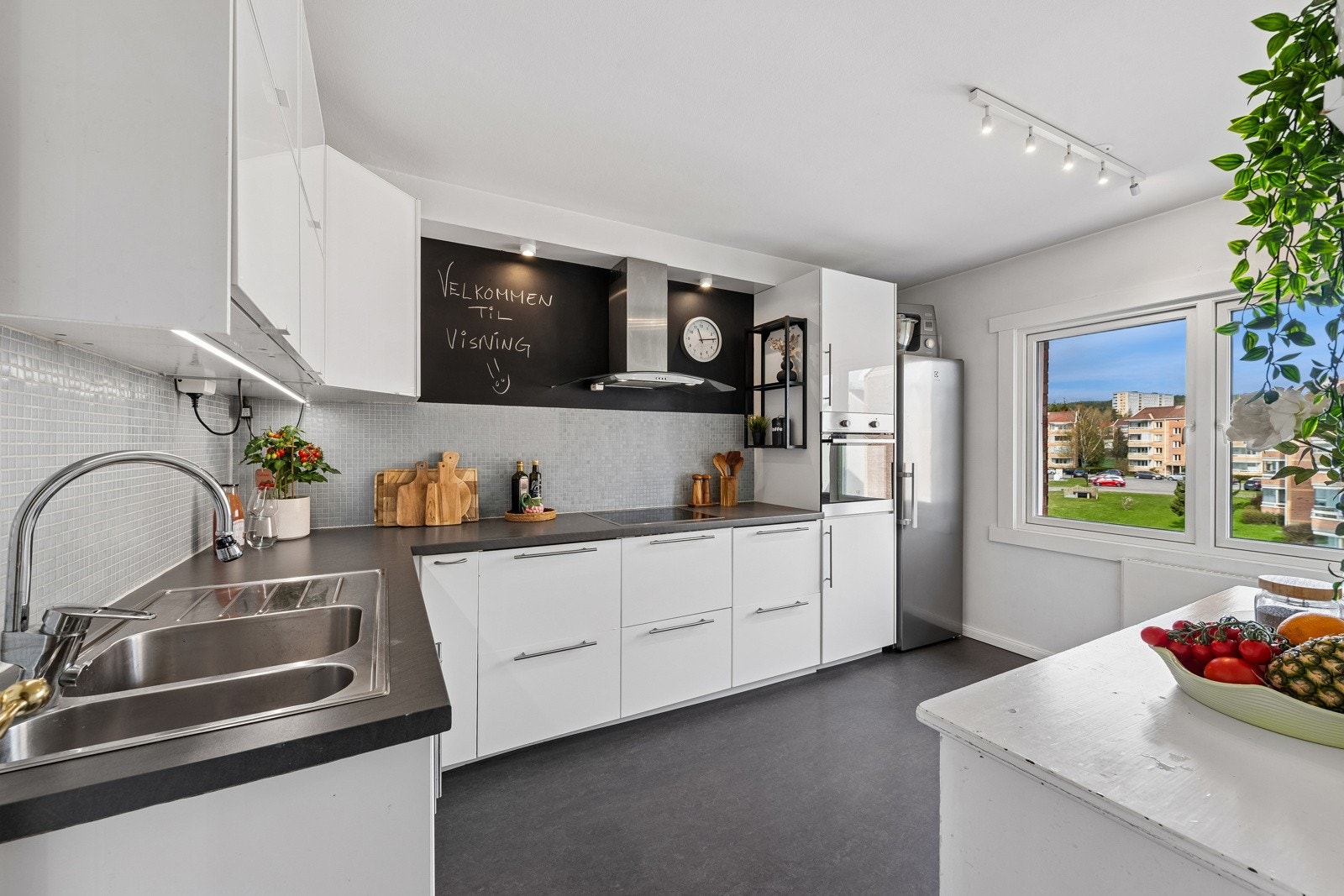 Glatt laminat kjøkkeninnredning, laminat benkeplate, mosaikk fliser over benk. Galleribilde