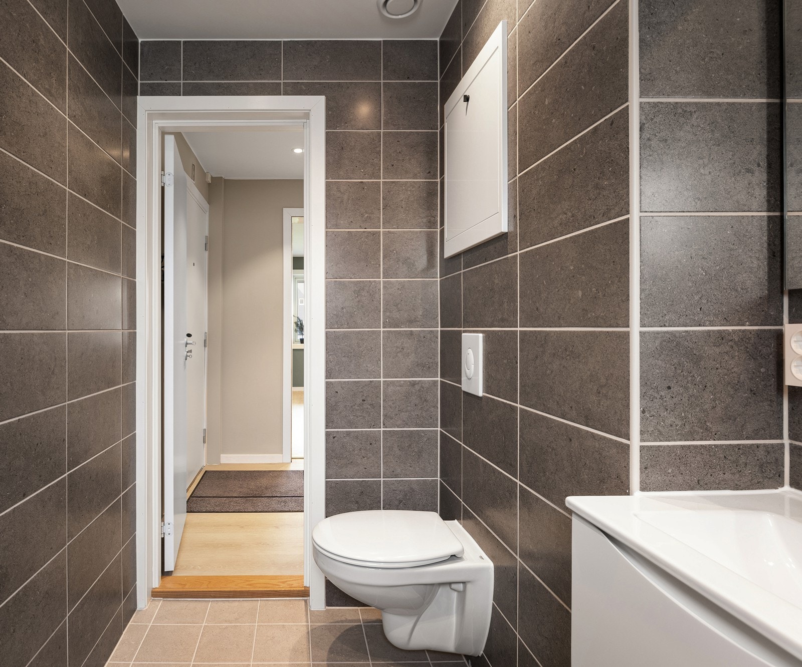 Badet har flislagte gulv og vegger, varmekabler i gulv og downlights i himling. Galleribilde