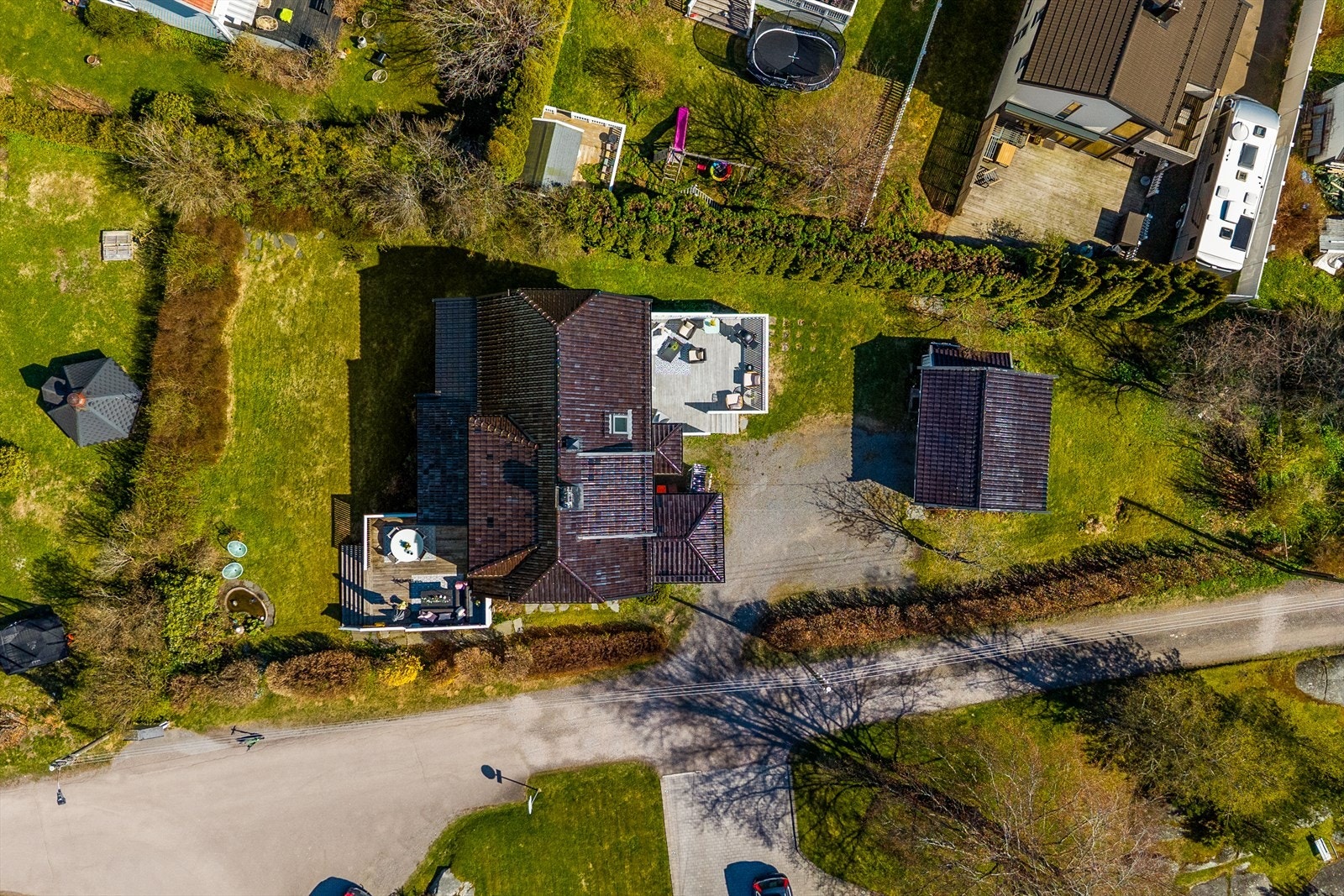 Oversiktsbilde som viser hele eiendommen med hage, terrasser, dam, gårdsplass og garasje. Galleribilde