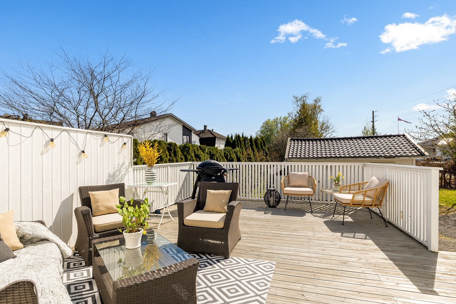 Stor og solrik terrasse med gode sitteplasser og skjermede omgivelser - et perfekt uteområde for sosiale sammenkomster, avslapning og hyggelige sommerkvelder. Galleribilde