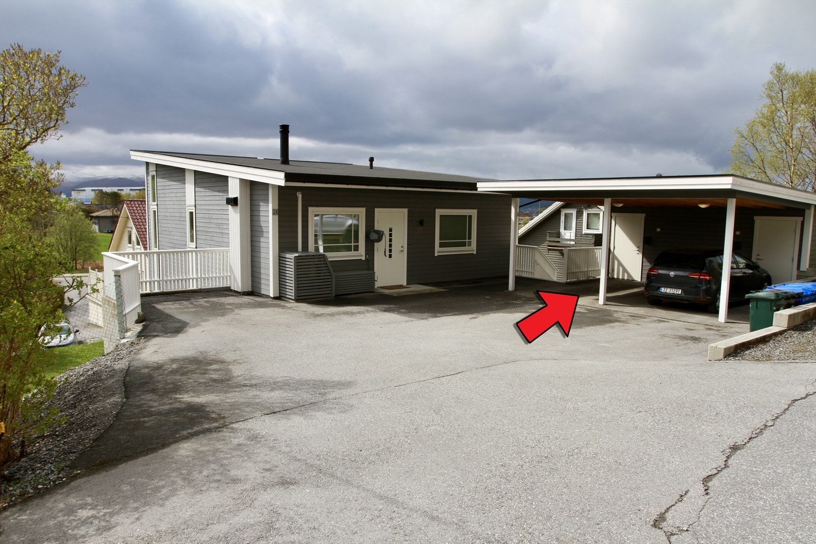 Flat og asfaltert innkøyring til carport med sportsbod Galleribilde