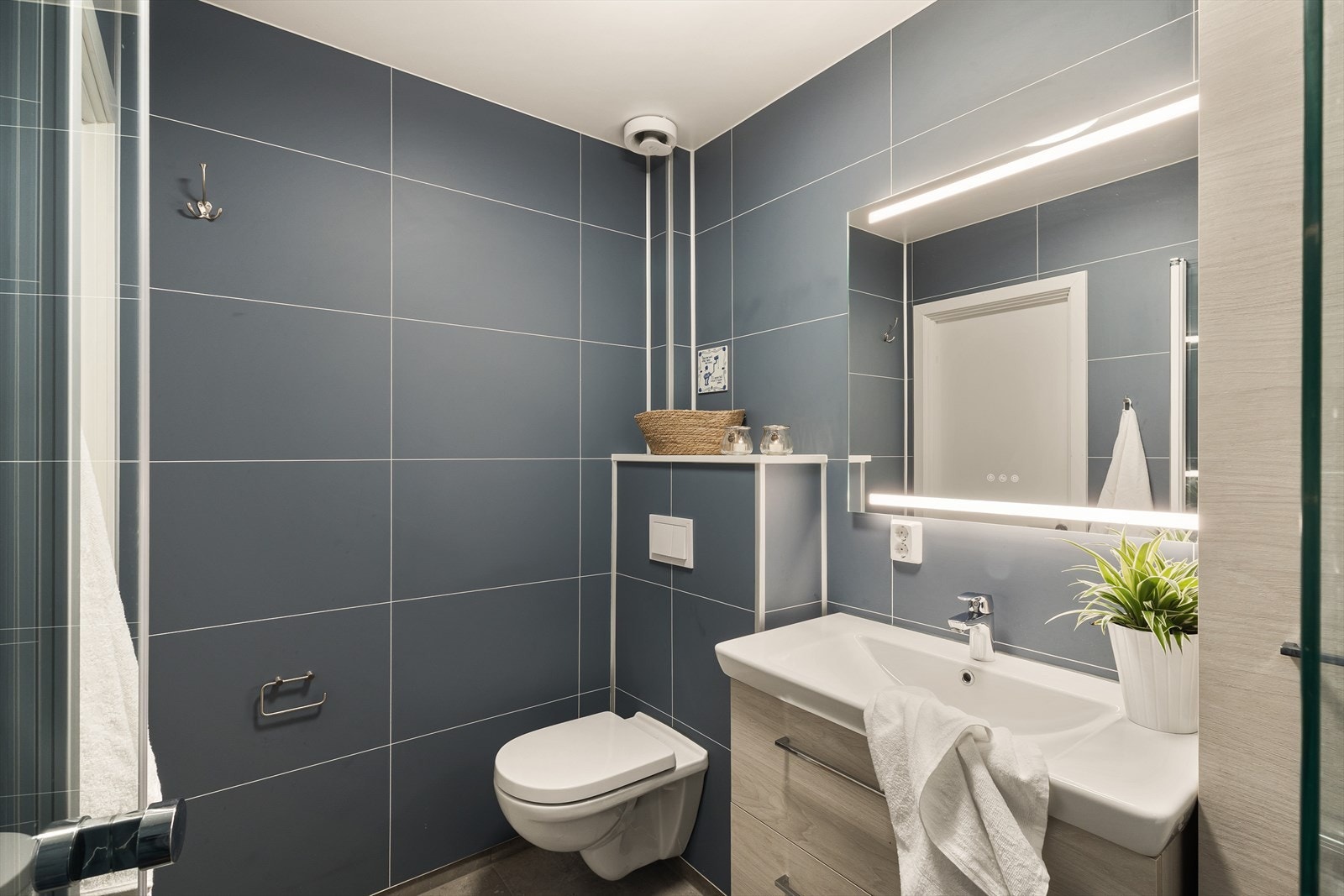 Badet har baderomsplater på vegger, malt himling og flislagt gulv med elektriske varmekabler som gir god komfort. Galleribilde