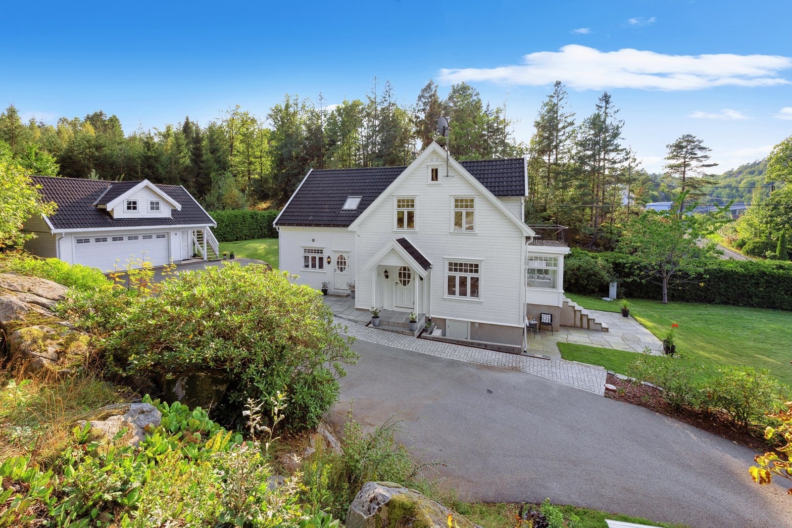 Huset er omkranset av en velpleid, usjenert hage med flotte steinarbeider bl.a. bestående av plattinger og trapper i skifer, samt asfaltert innkjørsel/gårdsplass. Galleribilde