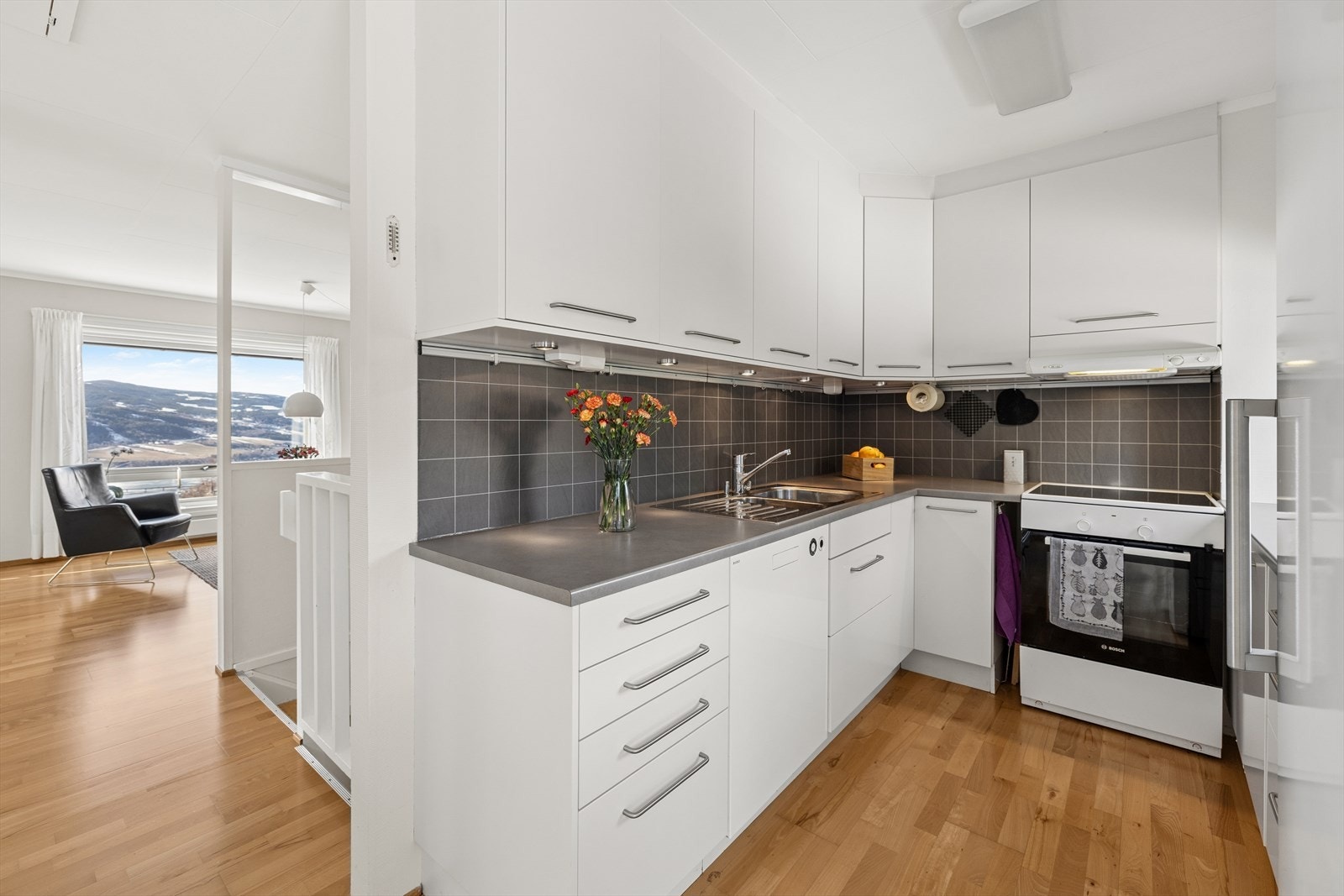 Kjøkkeninnredning med glatte fronter og laminert benkeplate. Galleribilde