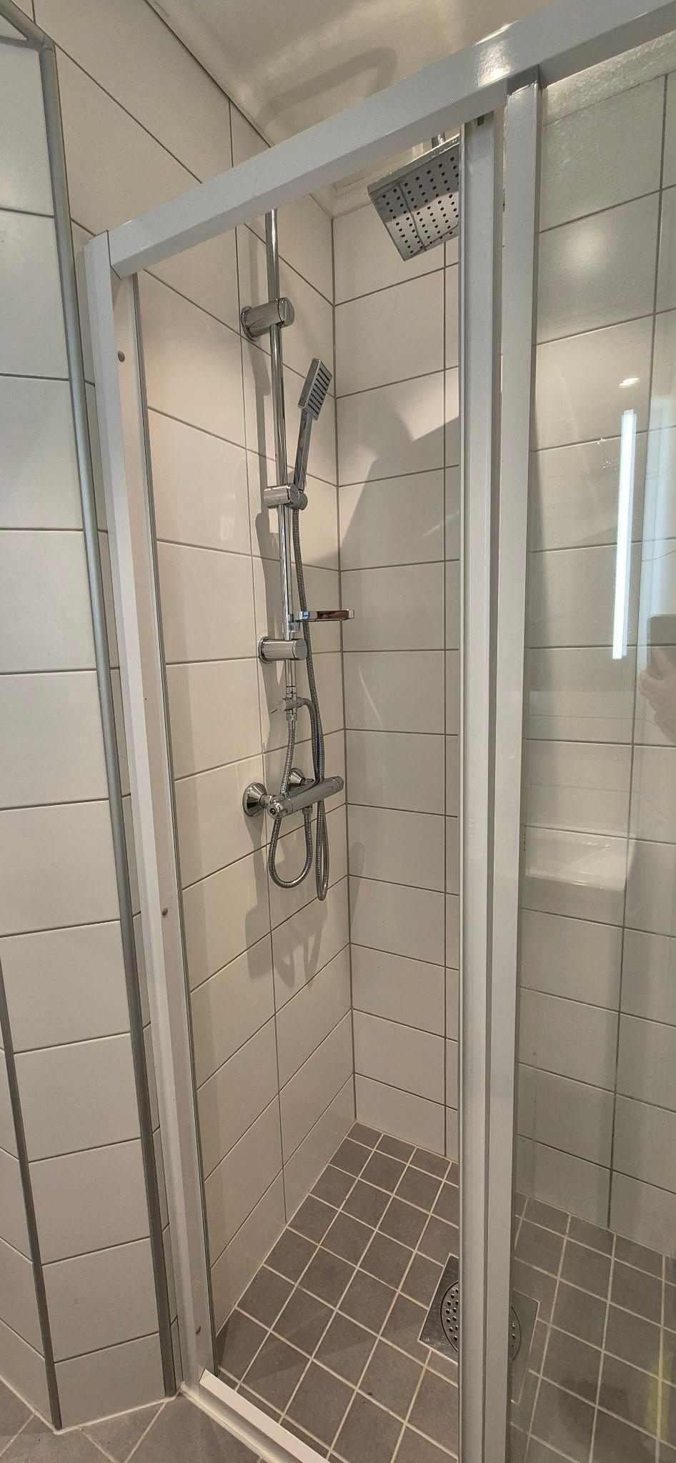 Praktisk bad med vegghengt toalett, dusjalkove med regndusj og vaskemaskin. Galleribilde
