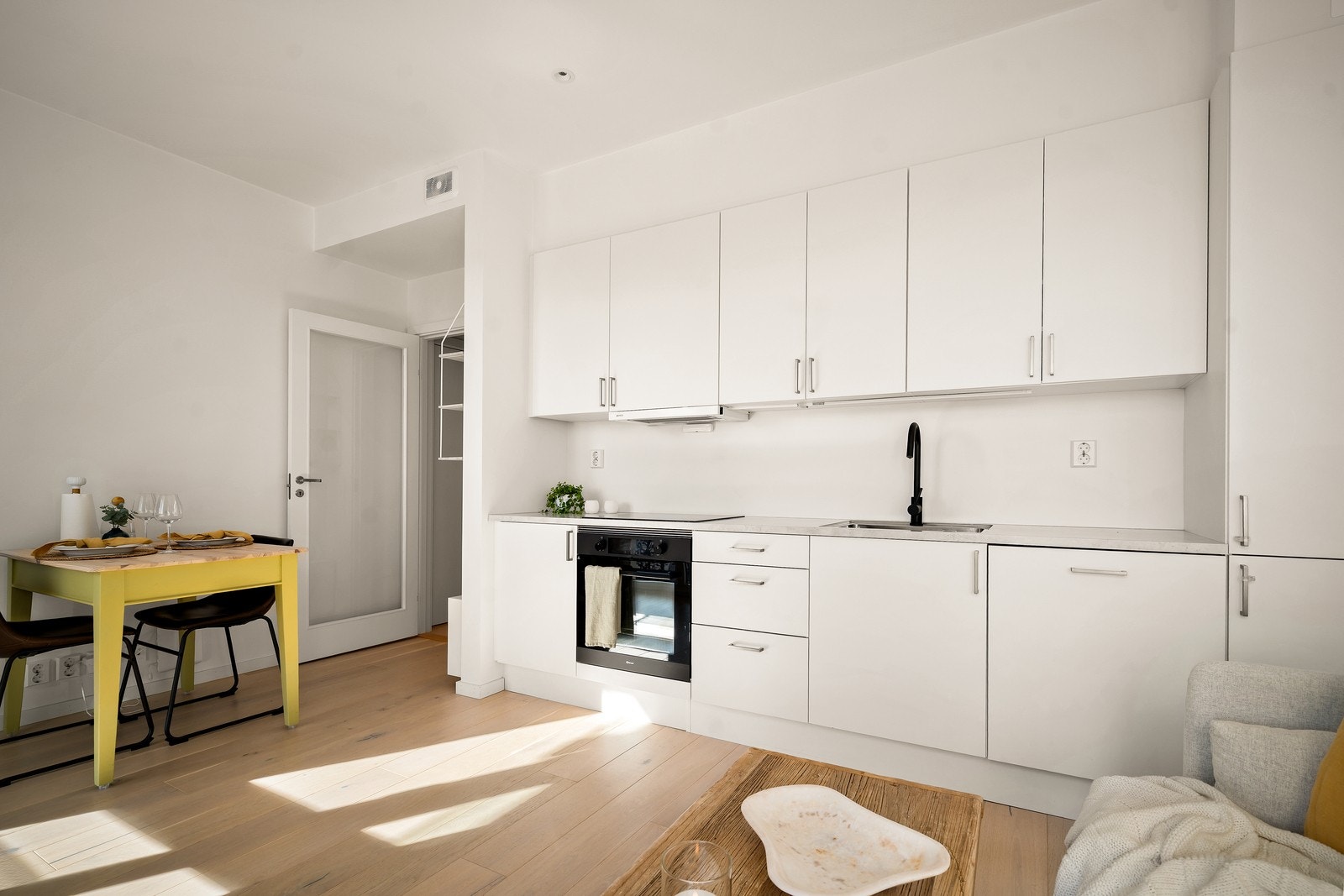 Kjøkkeninnredning med glatte fronter, laminatbenkeplate og avtrekk via balansert ventilasjonsanlegg. Galleribilde