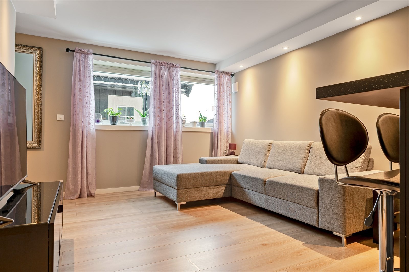Stuen i leiligheten har laminatgulv og god plass til sofa. Galleribilde