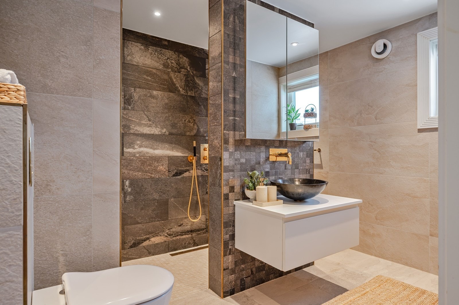 Badet er utstyrt med servant med underskap og speilskap, samt praktisk dusjnisje. Galleribilde