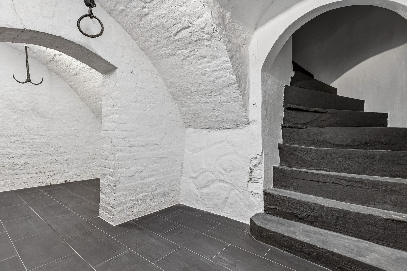 Fra felles yttergang leder trappen ned til en sjarmerende hvelvkjeller med tydelig karakter. Rommet har flislagt gulv, samt himling i hvitmalt teglstein, som bevarer det opprinnelige uttrykket. Galleribilde