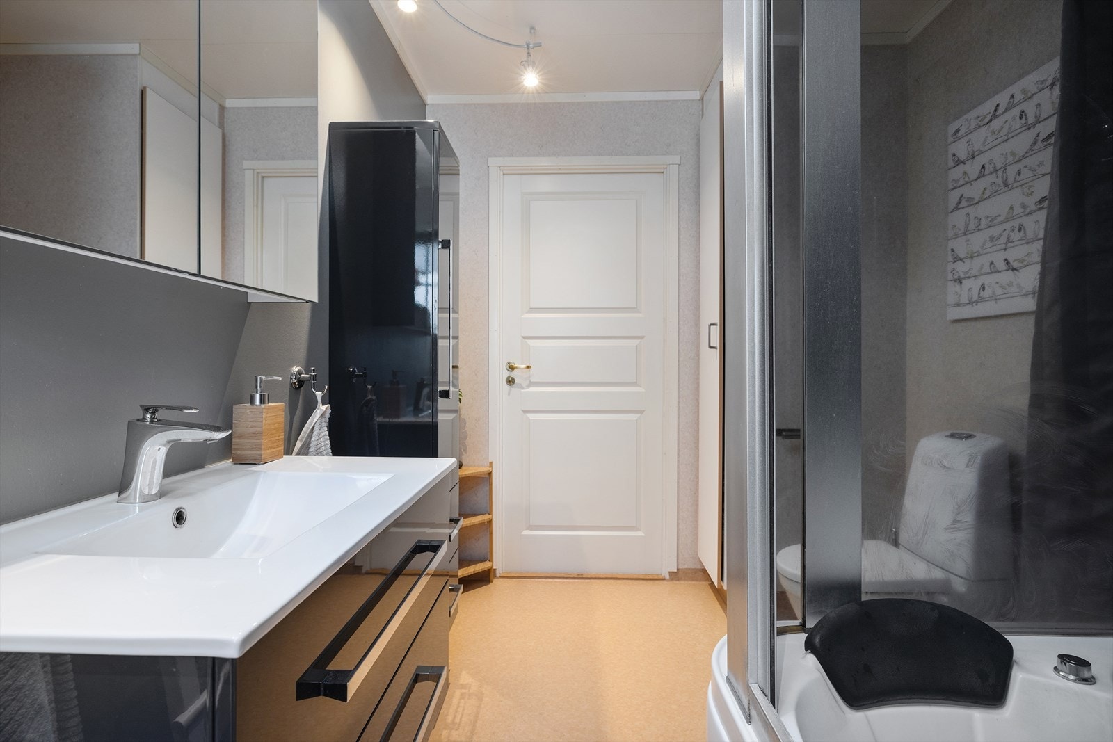 Badet i første etasje har vinylbelegg på gulv, våtromstapet på veggene og er utstyrt med dusjkabinett. Galleribilde