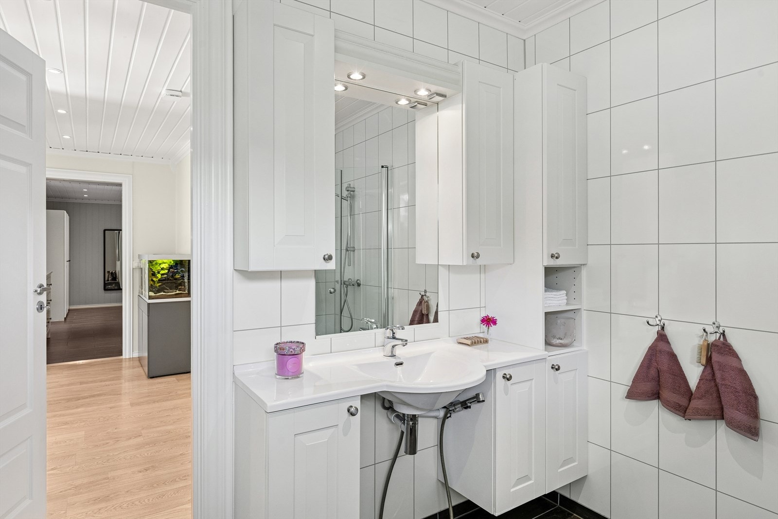 Badet har tilkomst fra gangen og er utstyrt med god oppbevaringsplass i innredningen. Galleribilde
