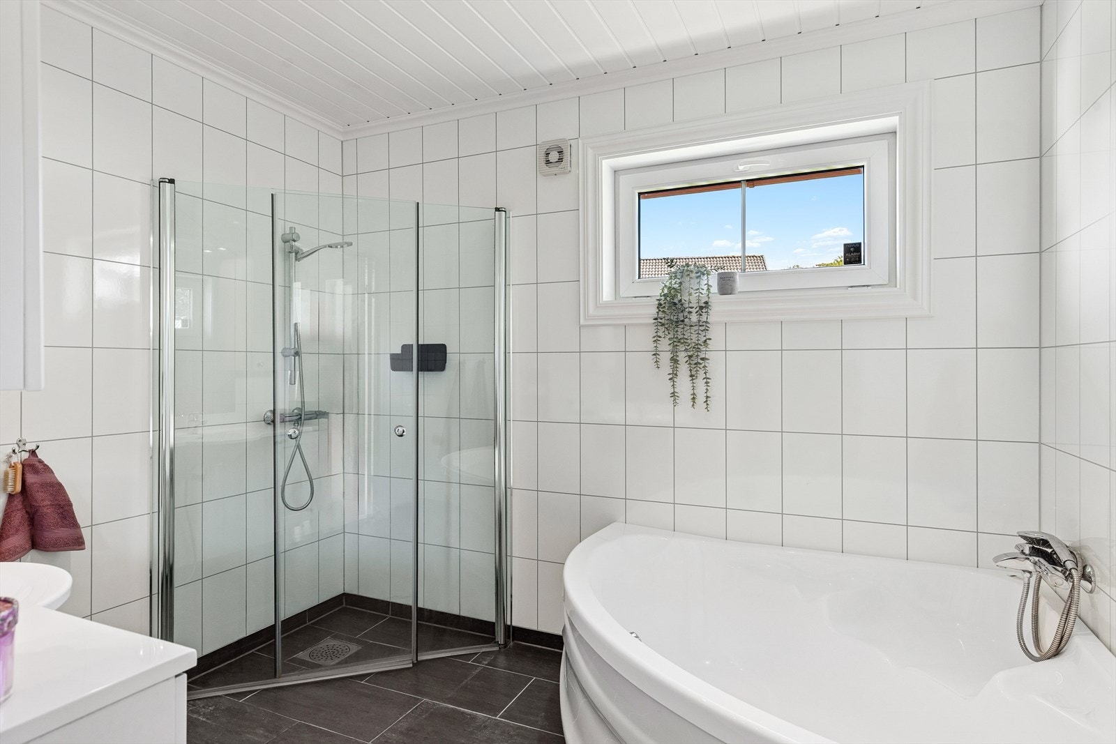 Badet er utstyrt med innredning med nedfelt servant og har flislagt gulv med varmekabler. Galleribilde