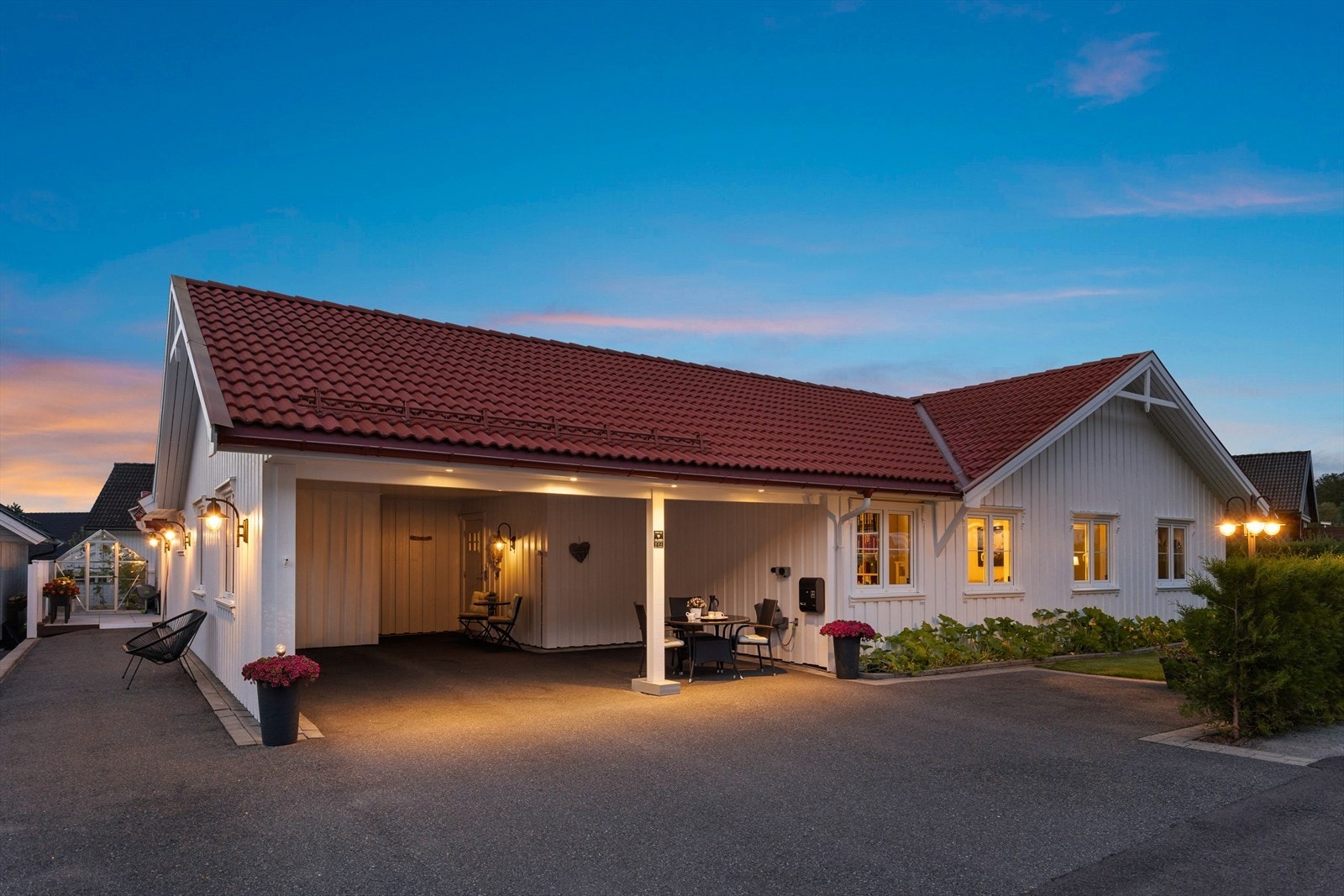 Asfaltert innkjørsel og carport med belysning gir et ryddig og innbydende inngangsparti. Galleribilde