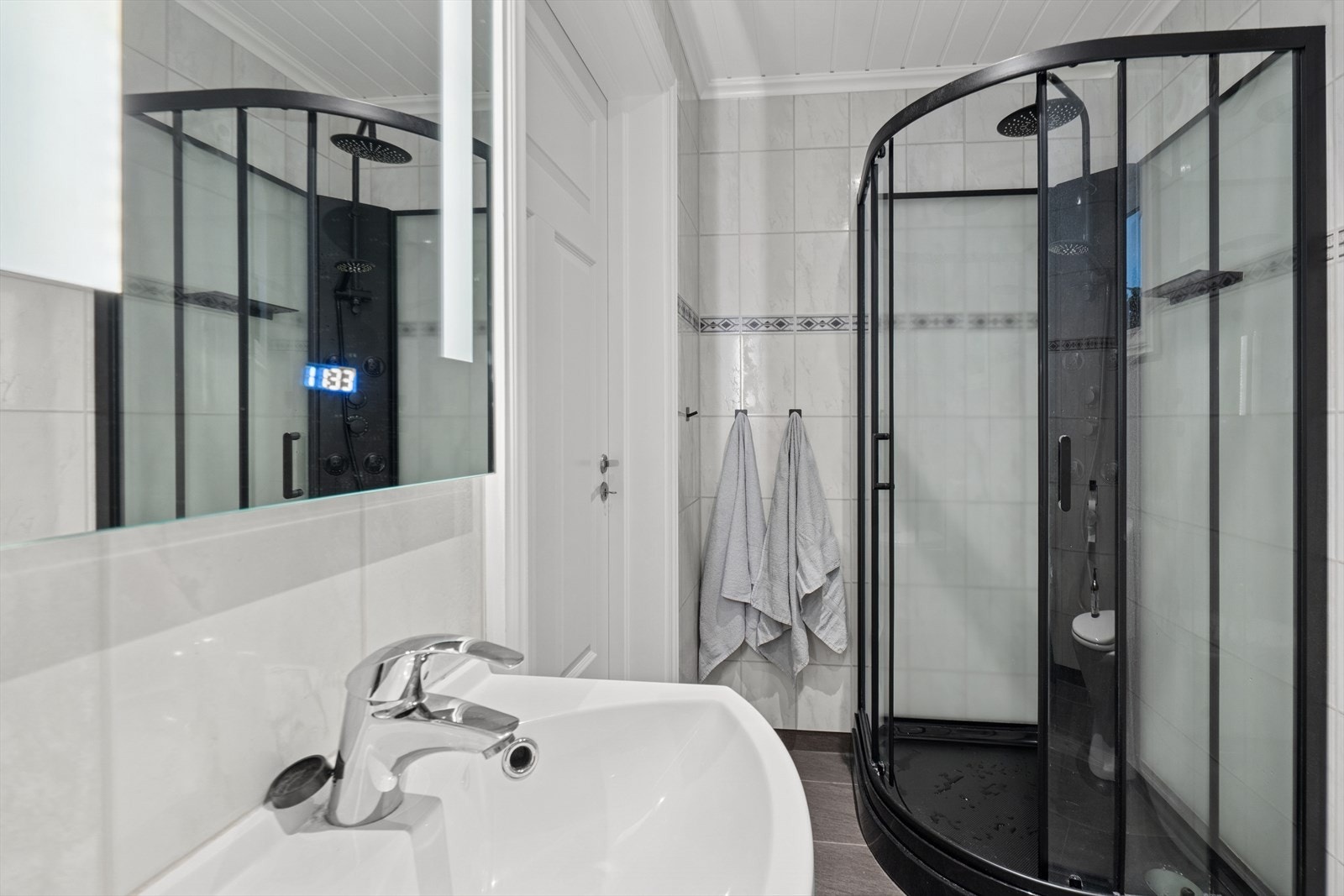 Badet har baderomsplater på veggene og downlights i taket, som gir en ren og vedlikeholdsfri overflate. Galleribilde