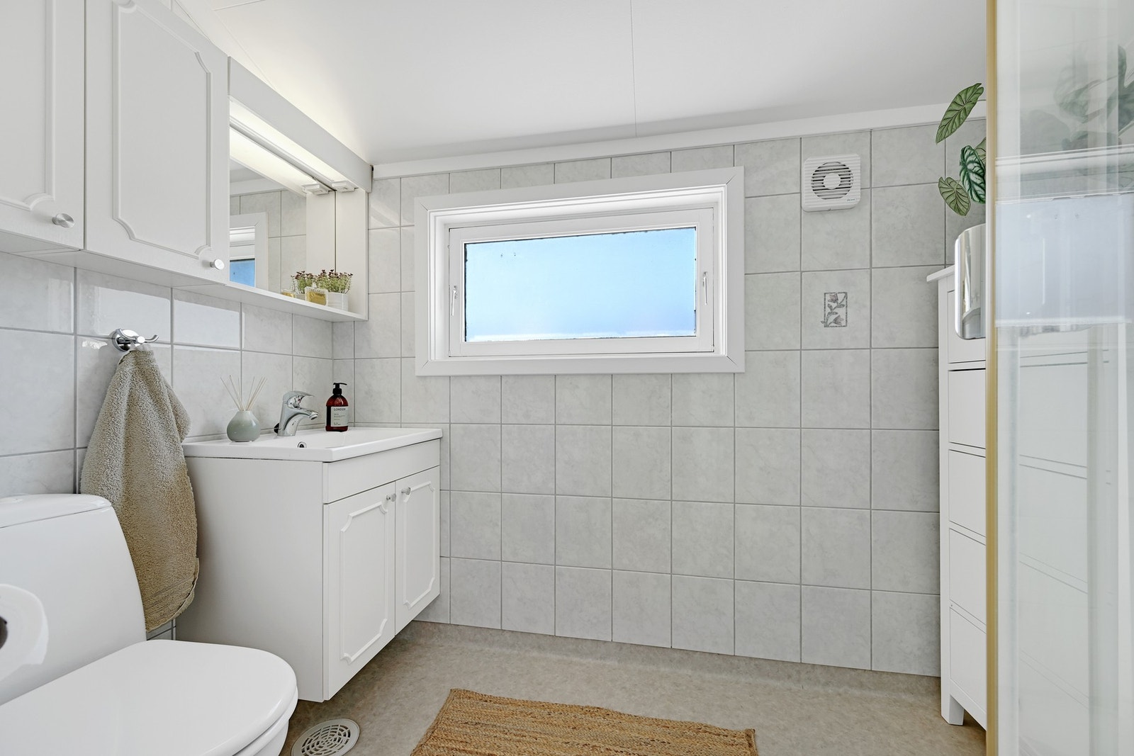 Badet i 2. etasje har vinylbelegg og varme i gulvet, fliser på veggene og lysmalt himling. Galleribilde