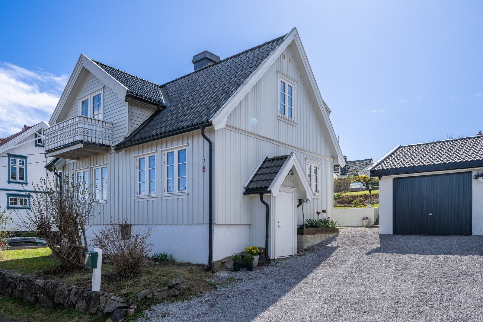Romslig gårdsrom med gruslagt innkjørsel og garasje. Galleribilde