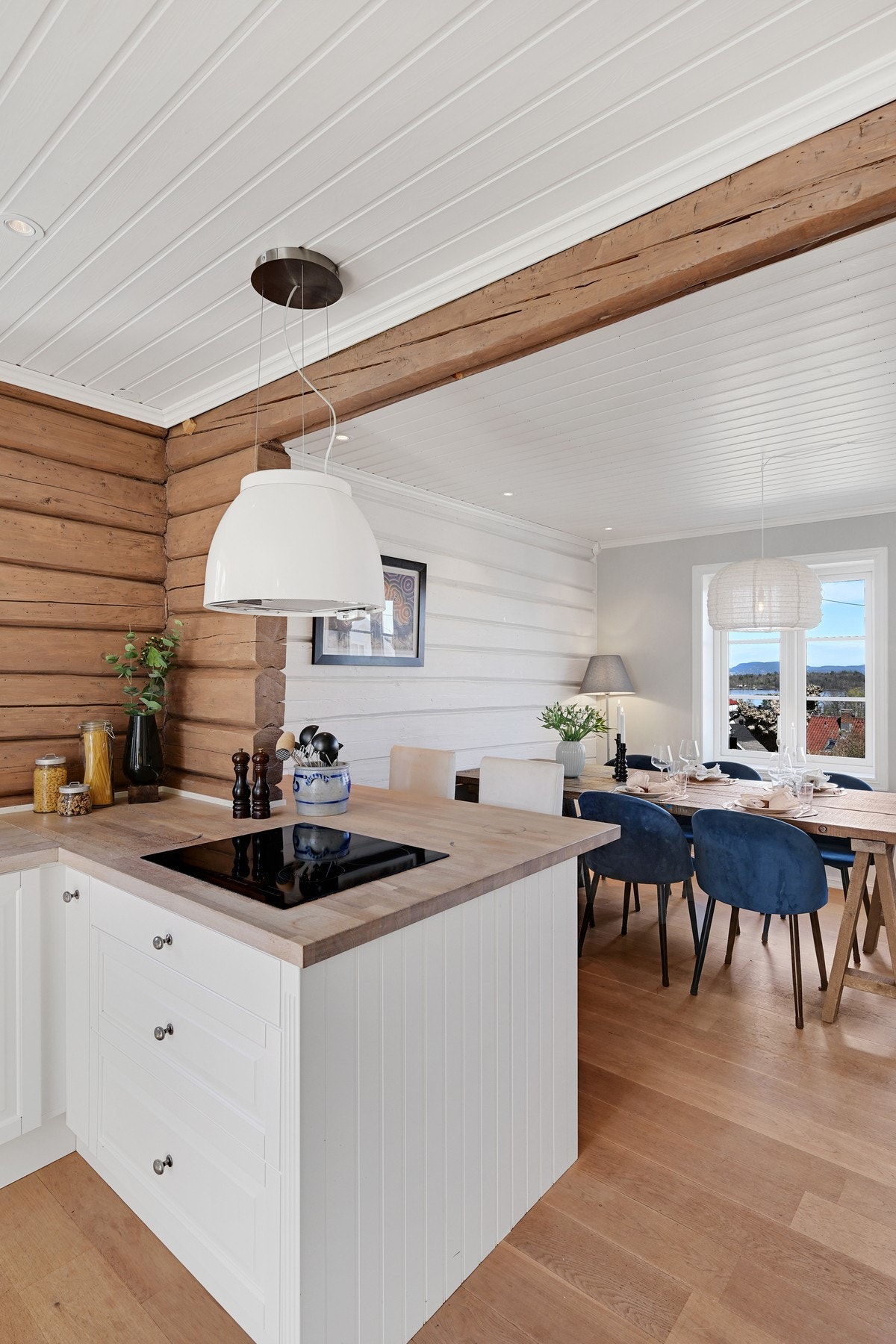 Åpen løsning fra kjøkken til spisestue gir en sosial atmosfære, perfekt for å underholde gjester mens måltid tilberedes. Galleribilde