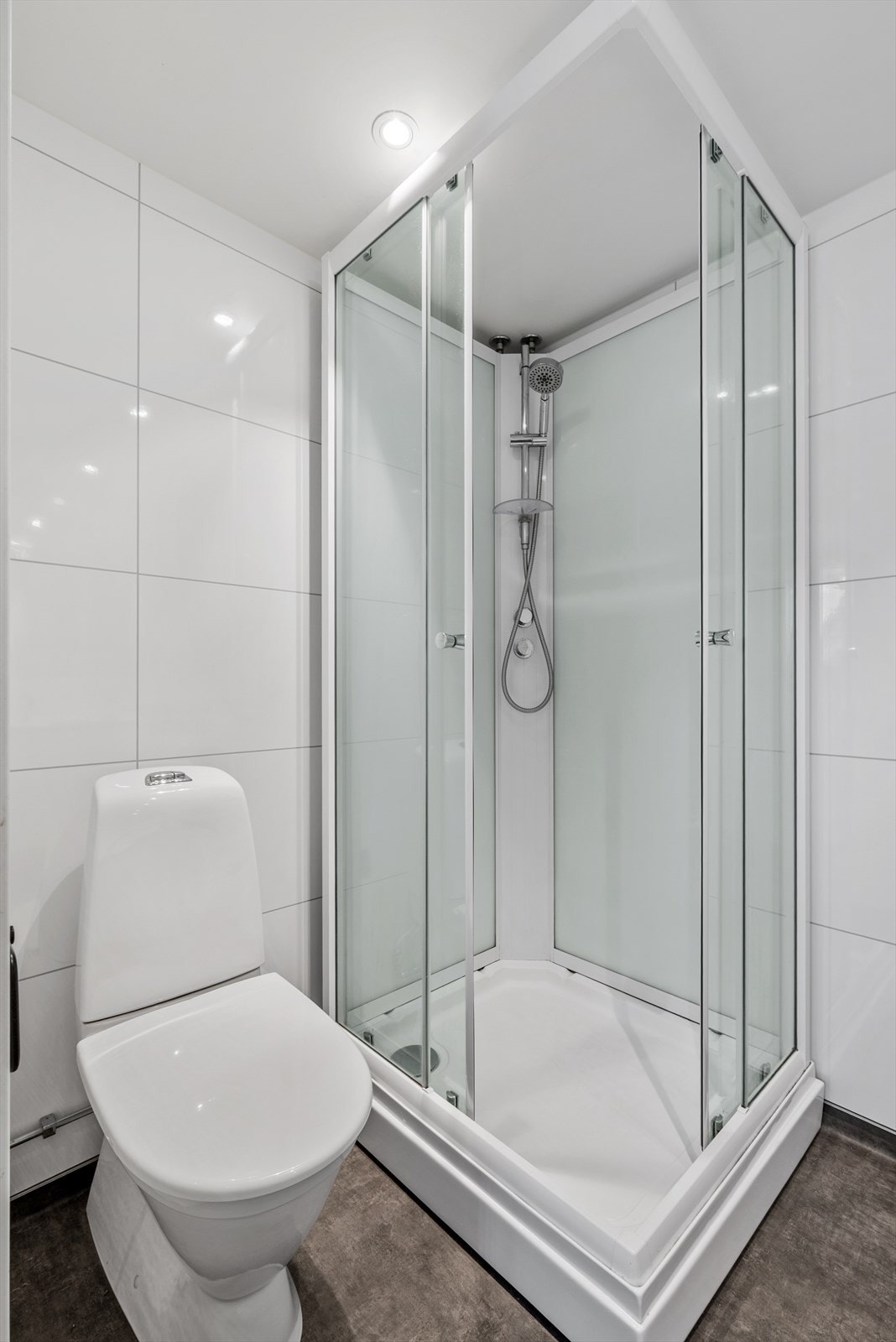 Badet har belegg på gulv med varmekabler, våtromsplater på vegger og gips i tak med spotter. Galleribilde