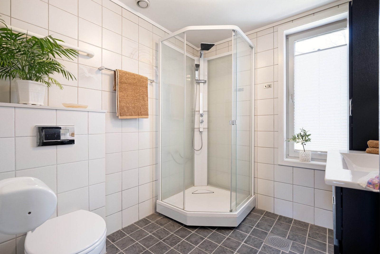 Badet er innredet med vegghengt servantinnredning og ovenpåliggende servant med armatur, samt speil med sidelys. Galleribilde