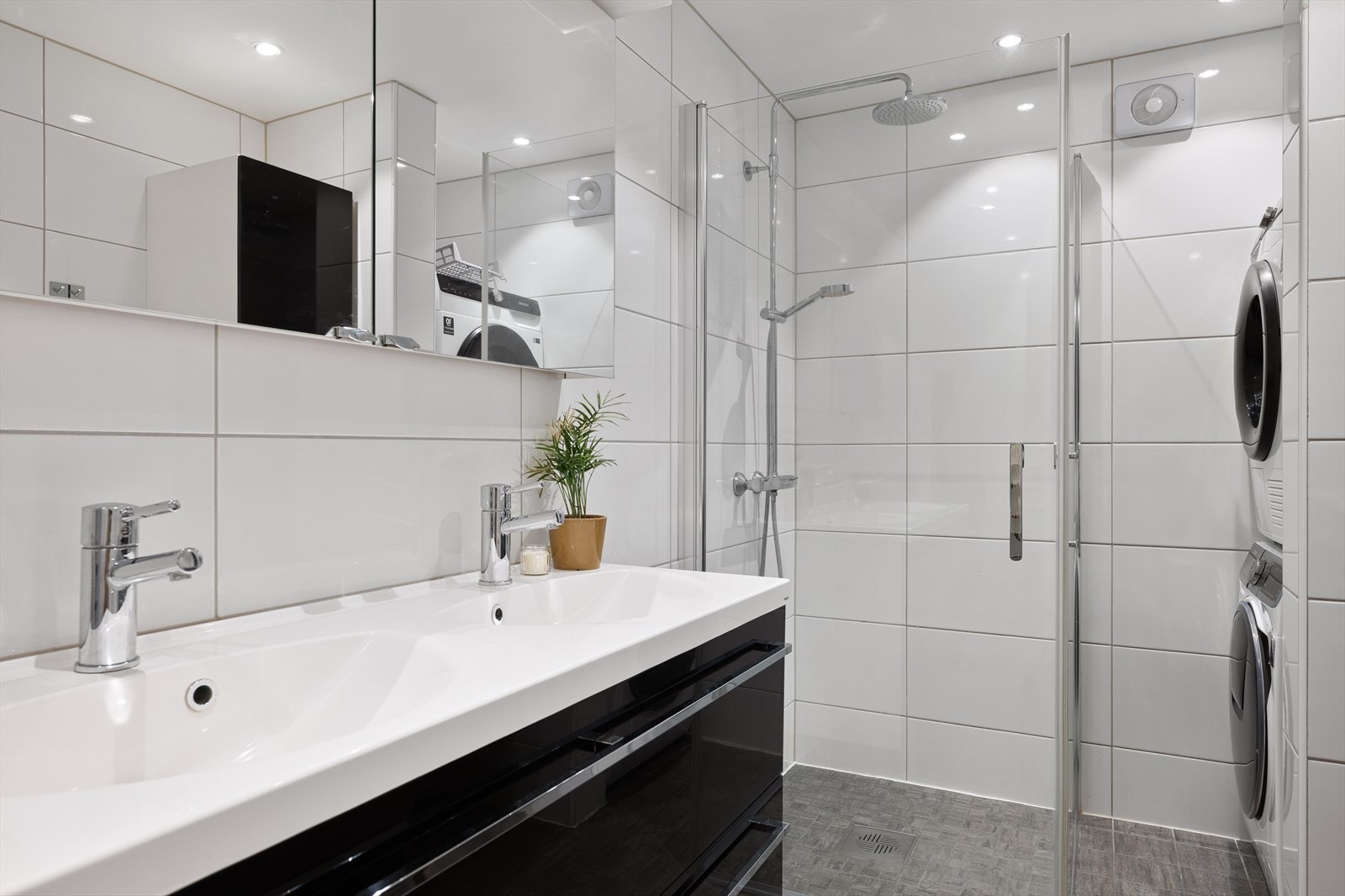 Badet er innredet med dobbel servant i innredning, innmurt badekar, dusjløsning og opplegg for vaskemaskin Galleribilde