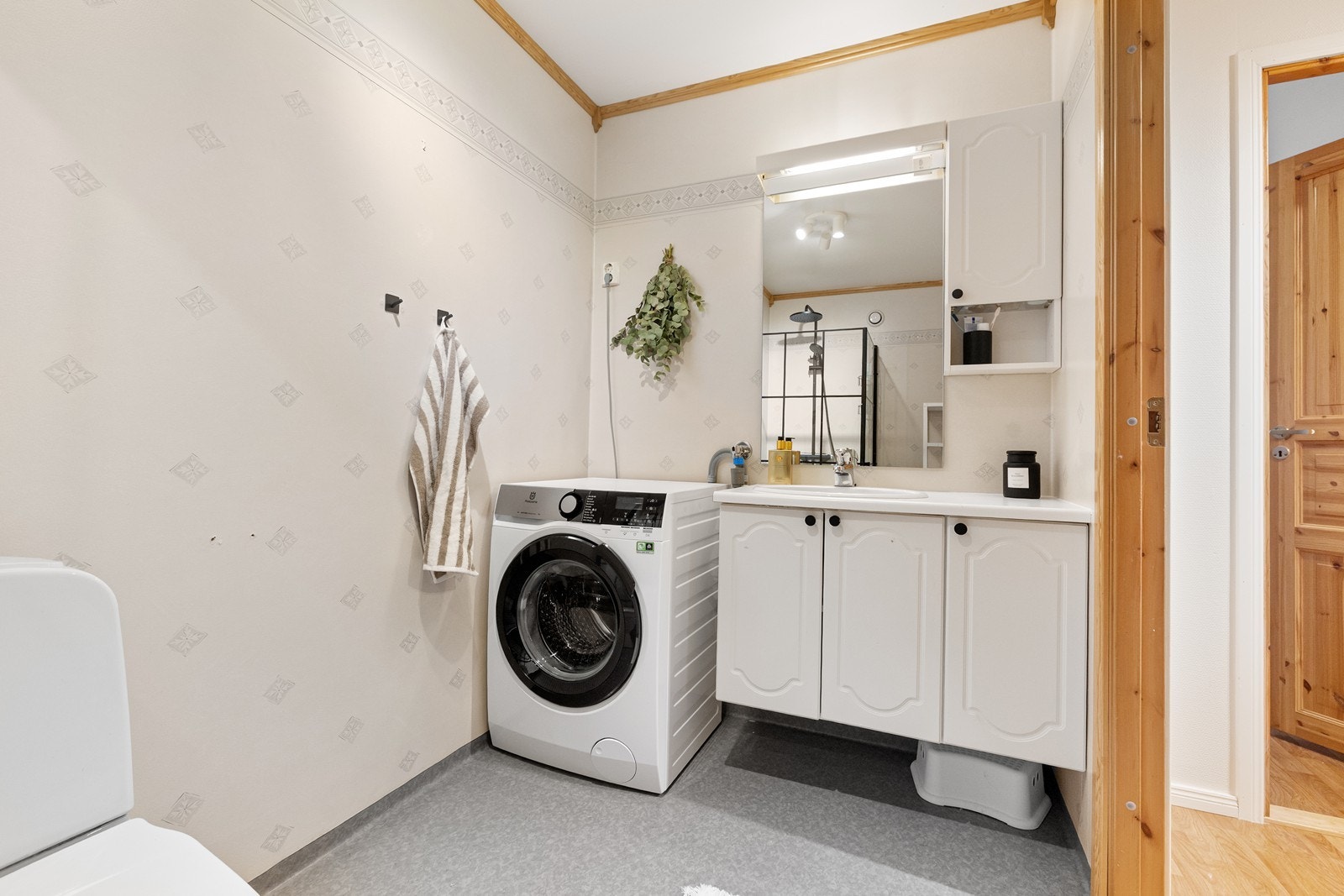 Badet er innredet med servant i baderomsinnredning, toalett, dusjhjørne og opplegg for vaskemaskin. Galleribilde