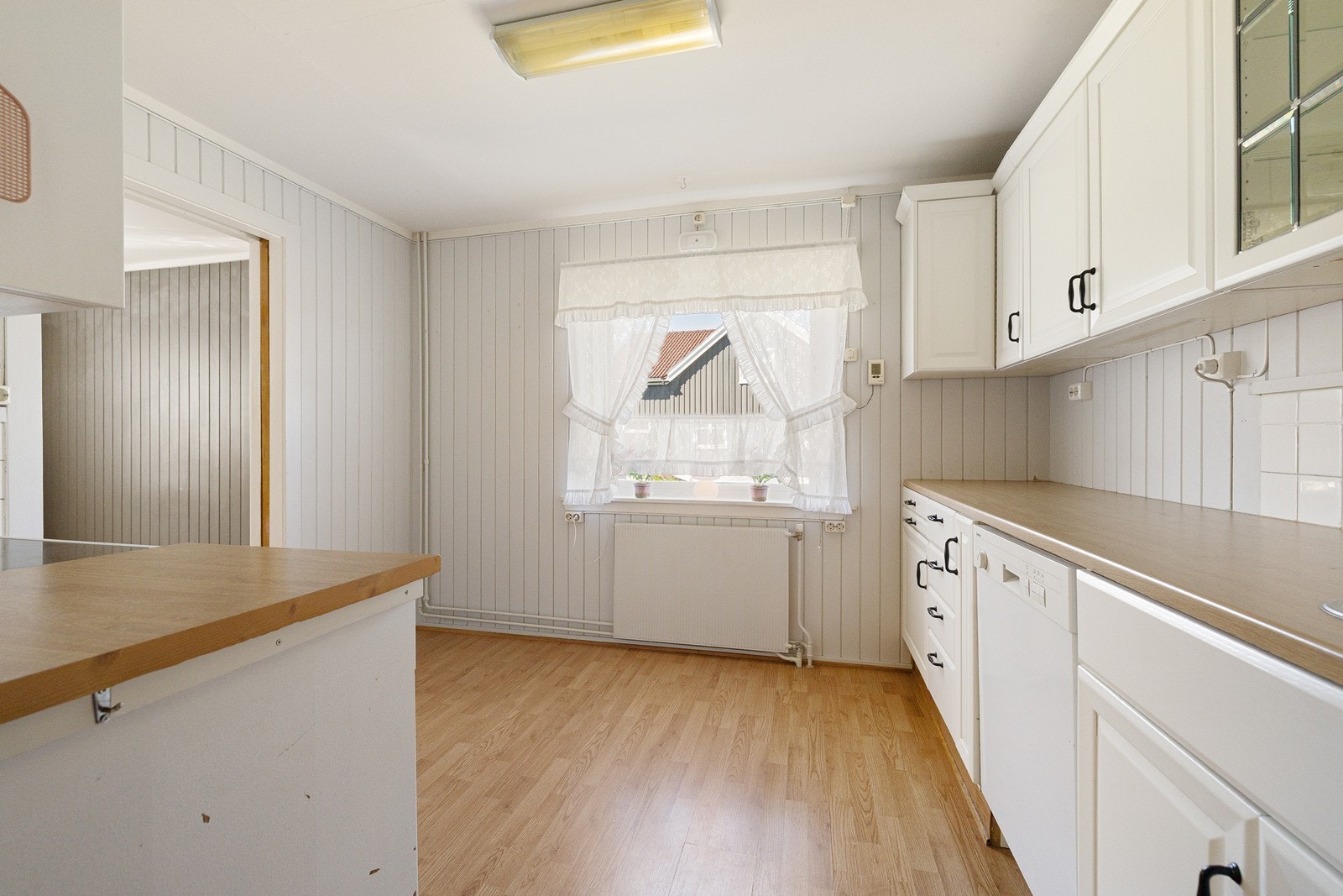 Kjøkkeninnredningen har hvite, profilerte fronter og laminert benkeplate. Galleribilde