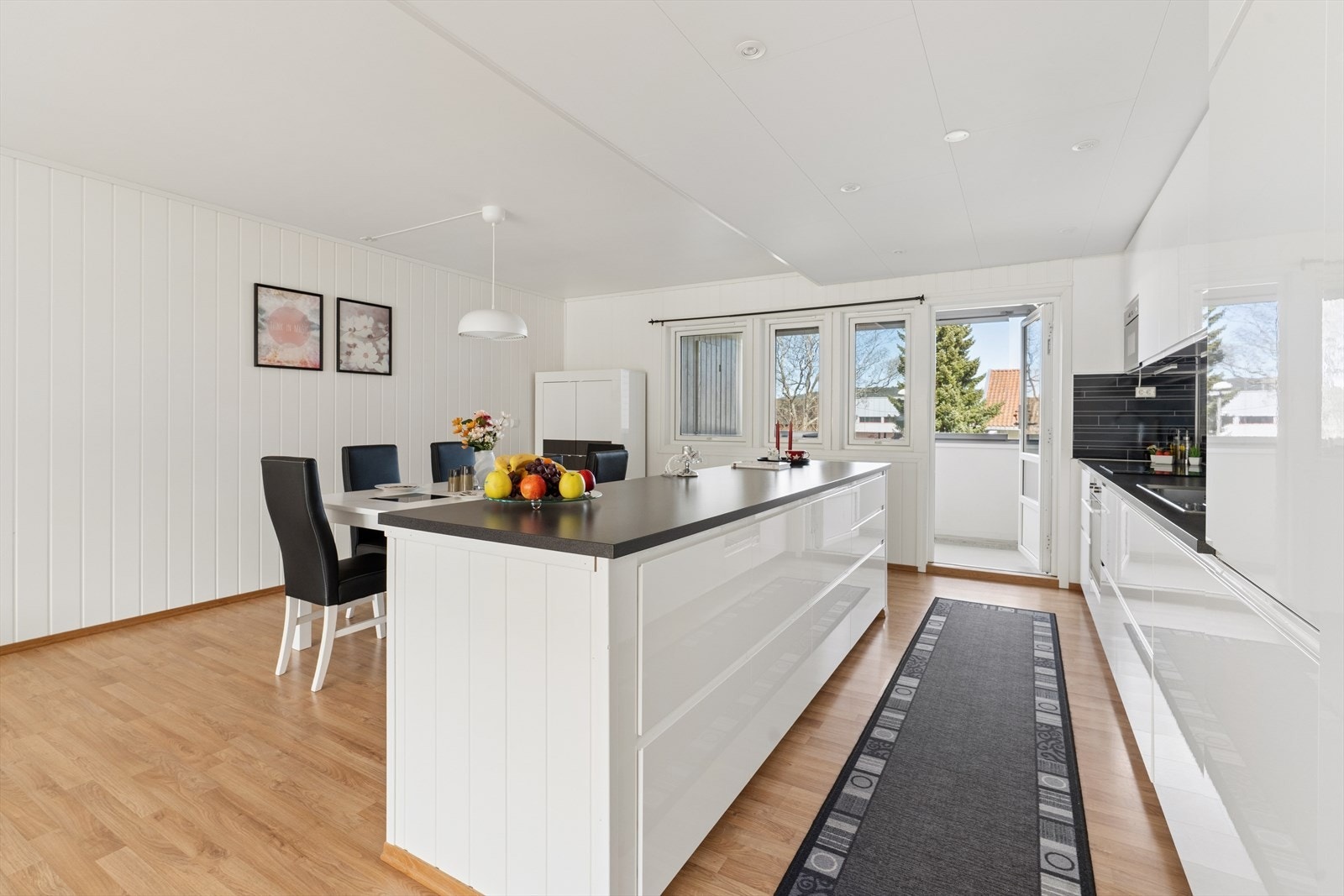 Kjøkkenet fremstår som moderne og stilrent, med romslig innredning i lyse, glatte fronter som gir et helhetlig og tidløst uttrykk. Galleribilde