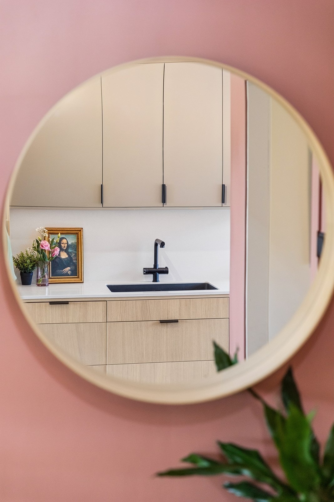 Detalj fra kjøkkenet som viser de sorte, minimalistiske håndtakene og den underlimte vasken. Galleribilde
