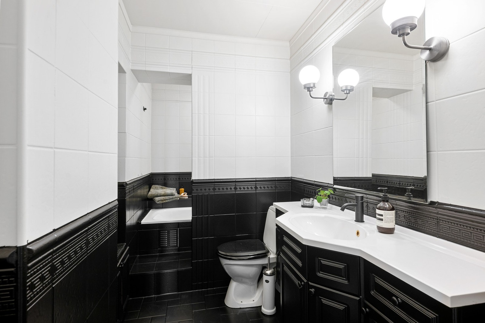 Baderomsinnredning bestående av benkeskap med profilerte fronter. Dusj i badekar, servant i helstøpt plate og gulvstående klosett. Badet er i følge tidligere salgsoppgave pusset opp i 2012. Galleribilde