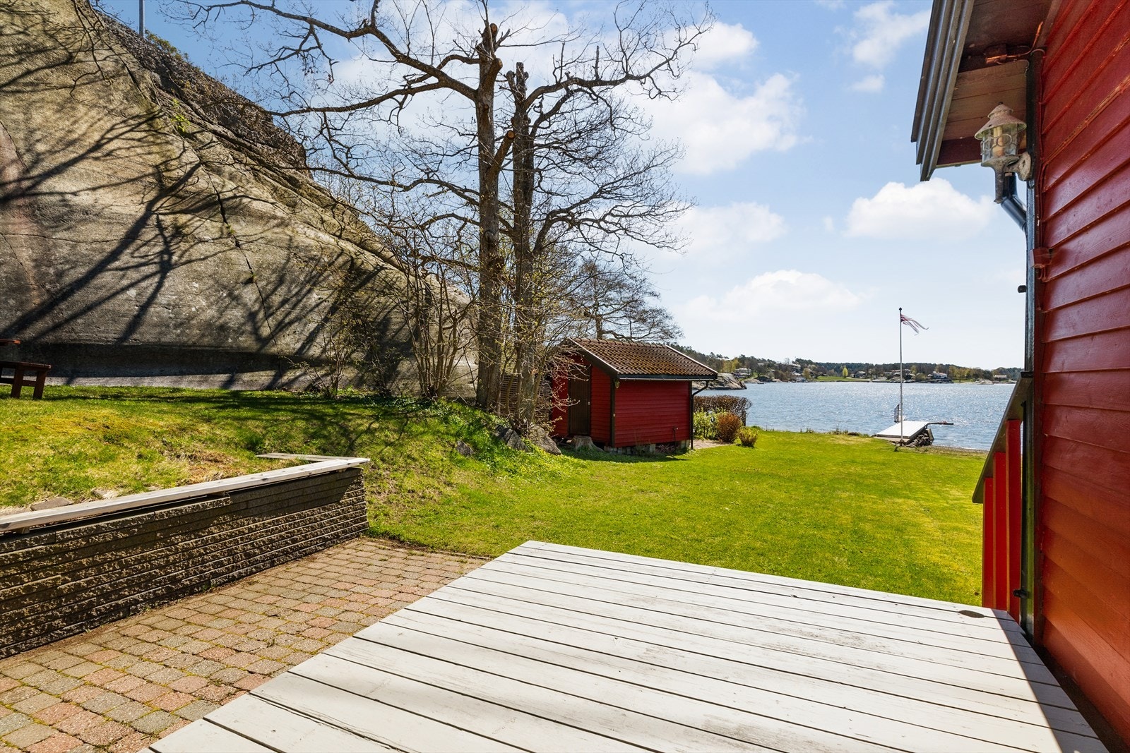 Fra terrassen på østsiden ser man ned mot hagen og sjøboden. Galleribilde