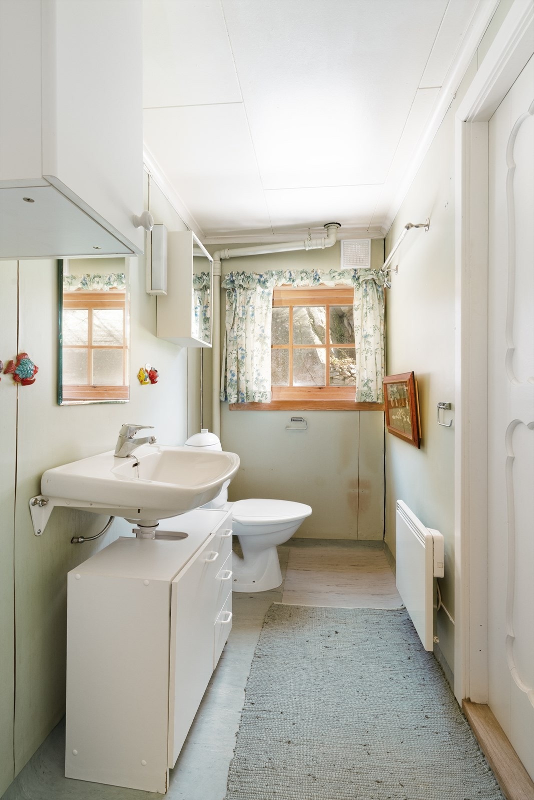 Badet i hovedhytta har vinylbelegg på gulv og baderomsplater på vegg. Rommet er utstyrt med servant, toalett og har naturlig ventilasjon. Galleribilde