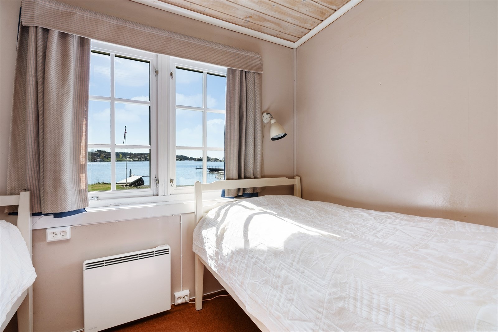 Vinduet gir en fin utsikt mot sjøen og hagen. Galleribilde