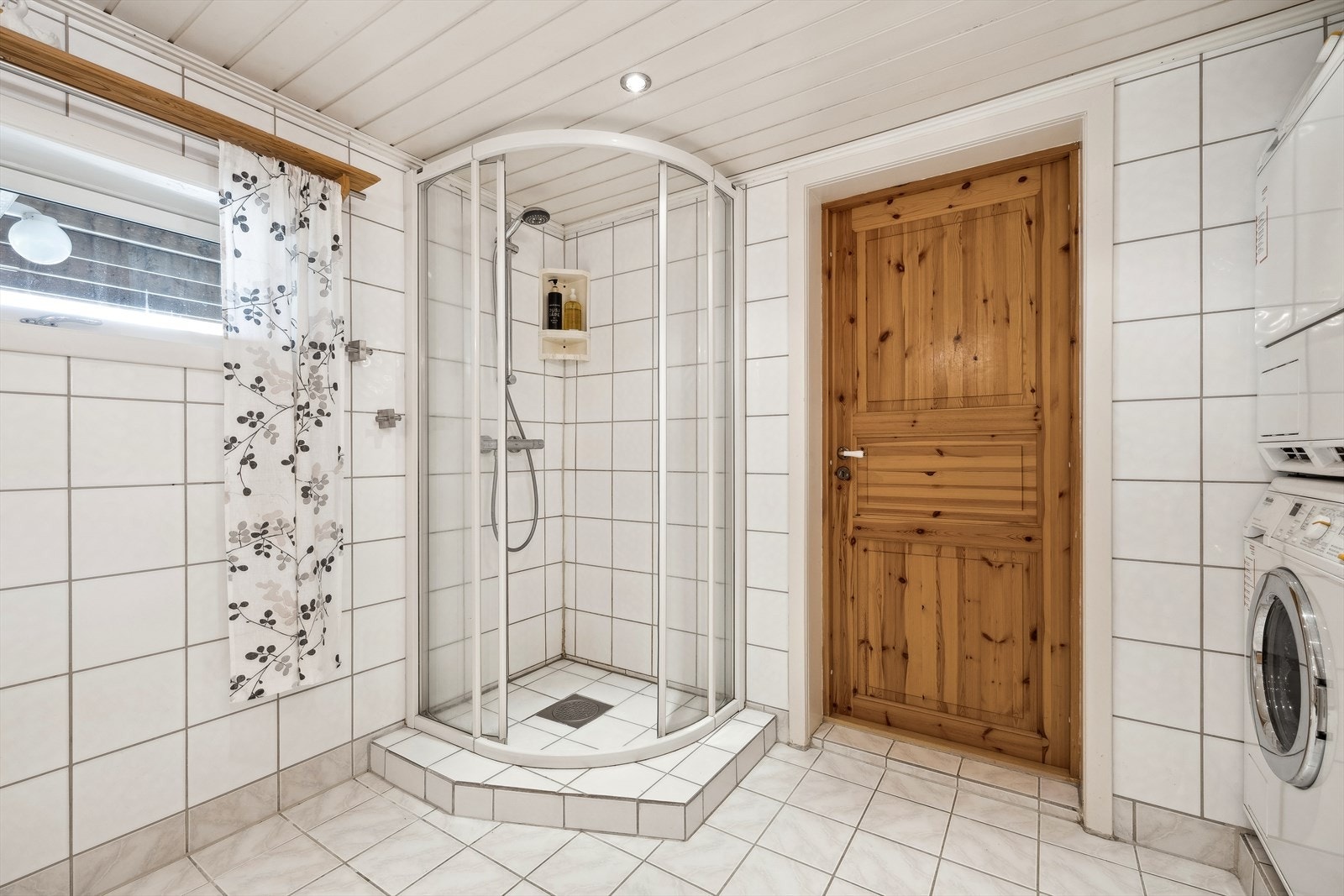 Dusjområdet har glassvegger som kan felles inn, og et veggmontert dusjsett med hånddusj. Galleribilde