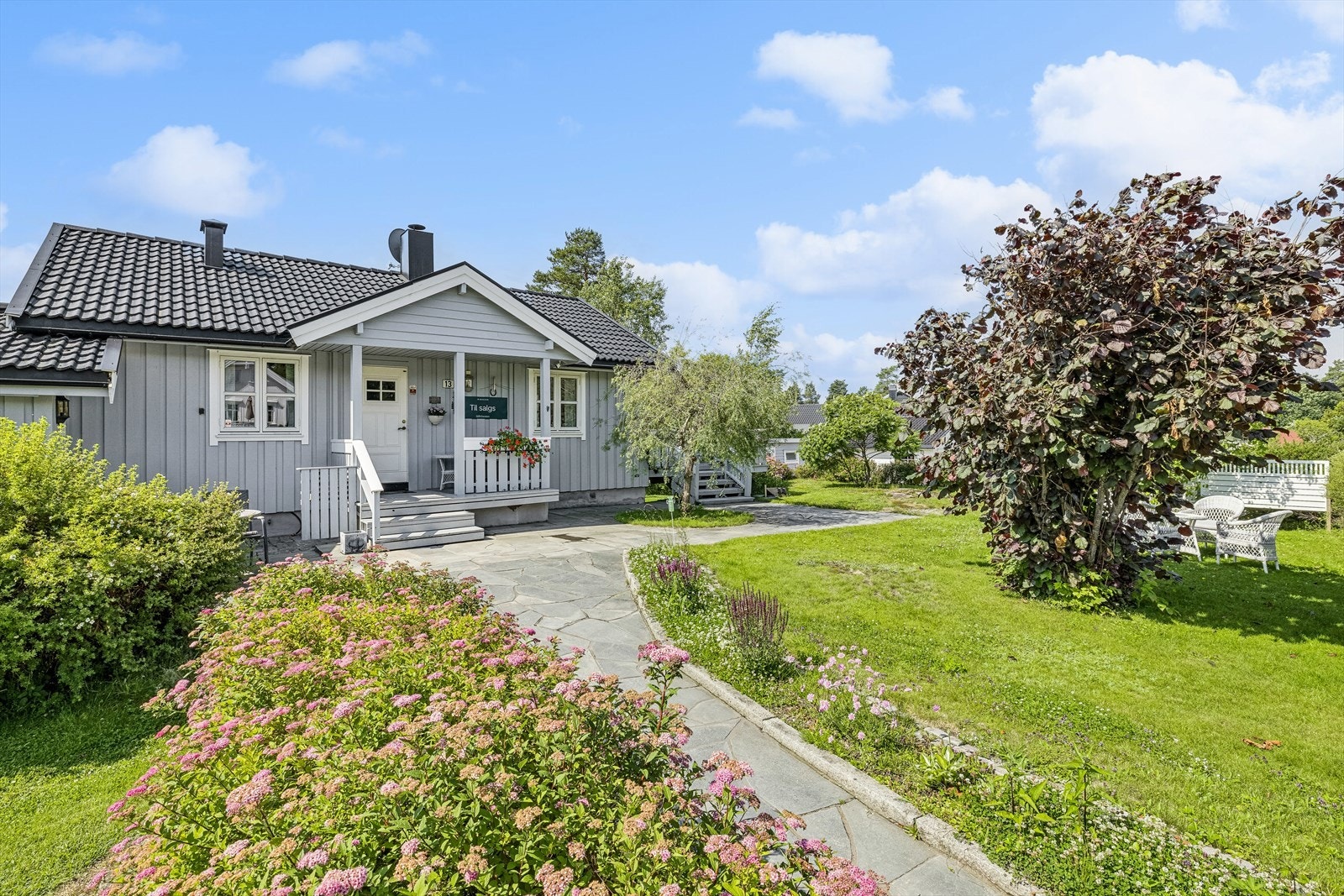 Eiendommen gir et innbydende inntrykk med en vakker hage. Galleribilde