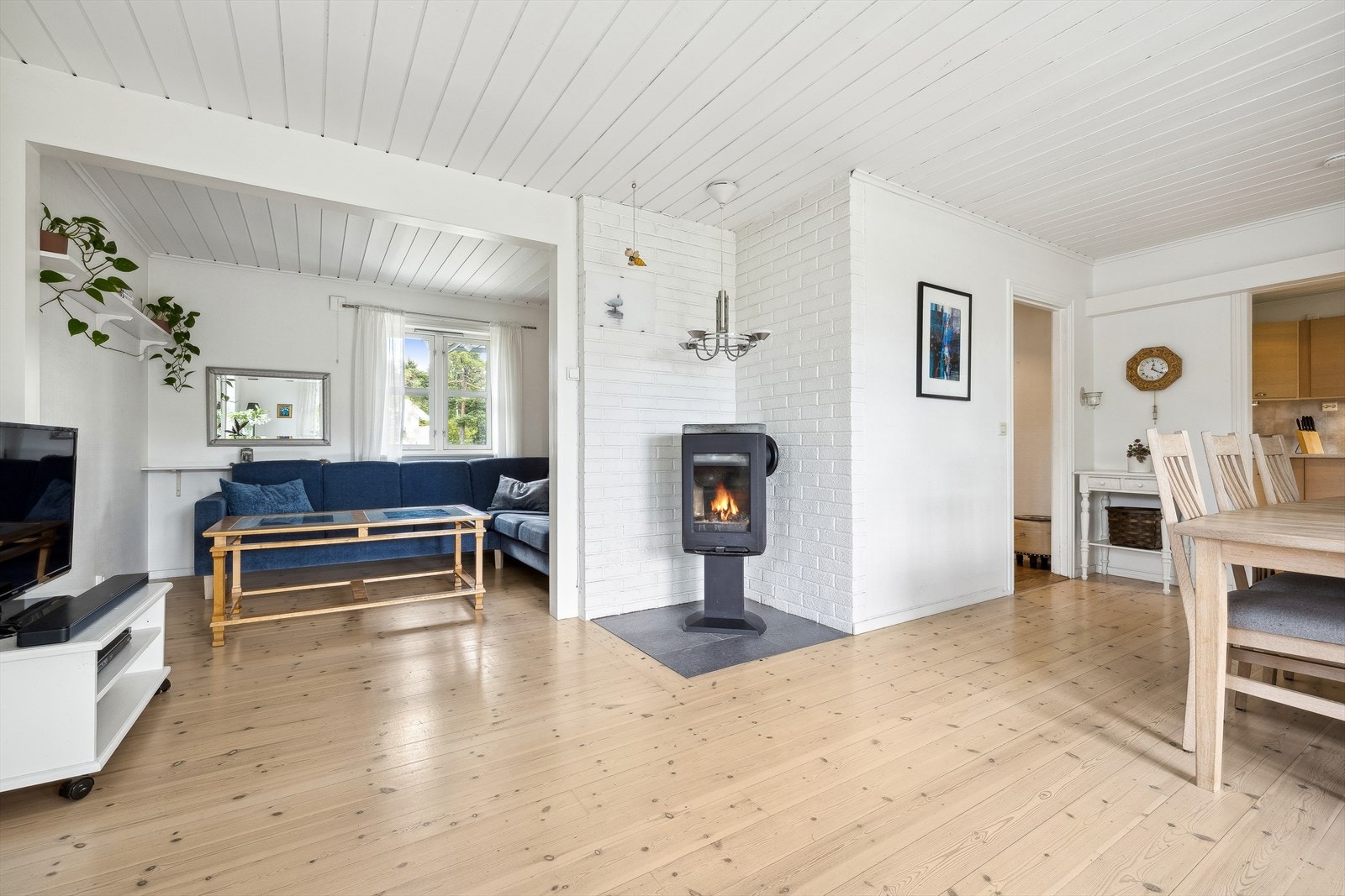 Store vinduer slipper inn naturlig dagslys, og en sentralt plassert vedovn skaper en lun og koselig atmosfære. Galleribilde