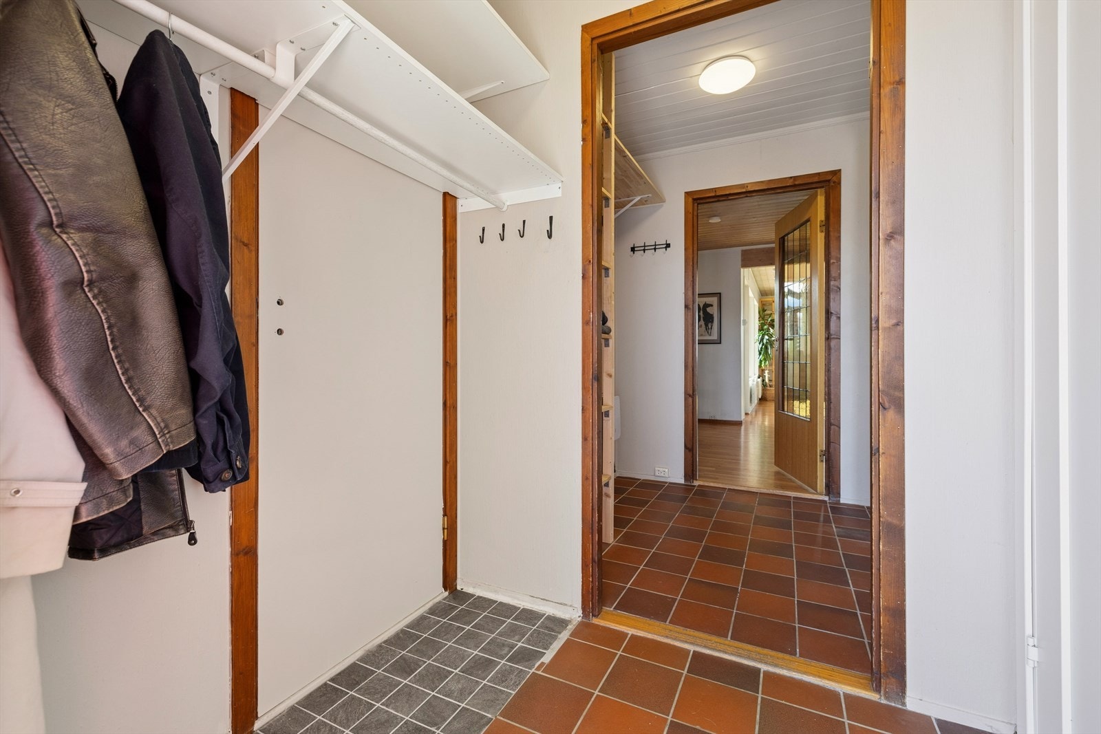 Romslig entré som leder inn til en mellomgang - god plass til ulike garderobeløsninger Galleribilde