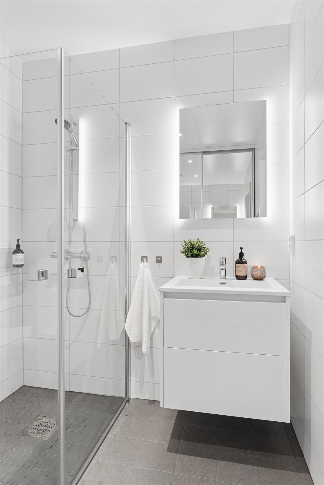 Downlights i taket og integrert belysning i speilet gir godt lys på badet. Galleribilde