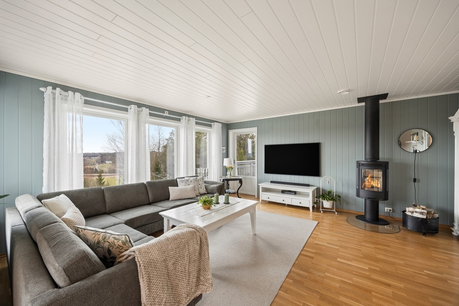 En moderne vedovn med isolert stålpipe gir både effektiv varme og en hyggelig atmosfære. Galleribilde