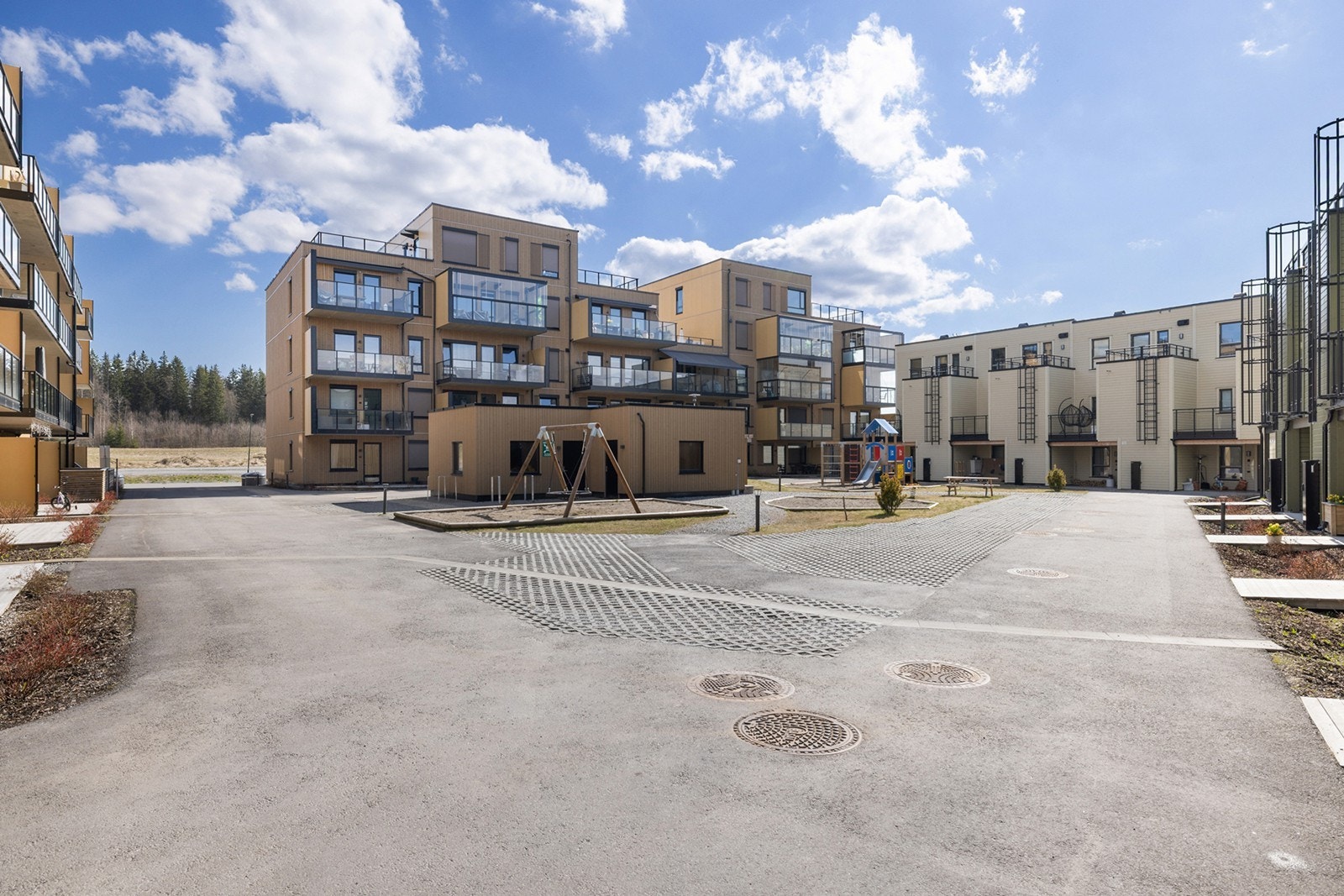 Fellesarealet og er pent opparbeidet med asfalterte internveier, gressplen og lekearealer, beplantning, sittegrupper. Galleribilde