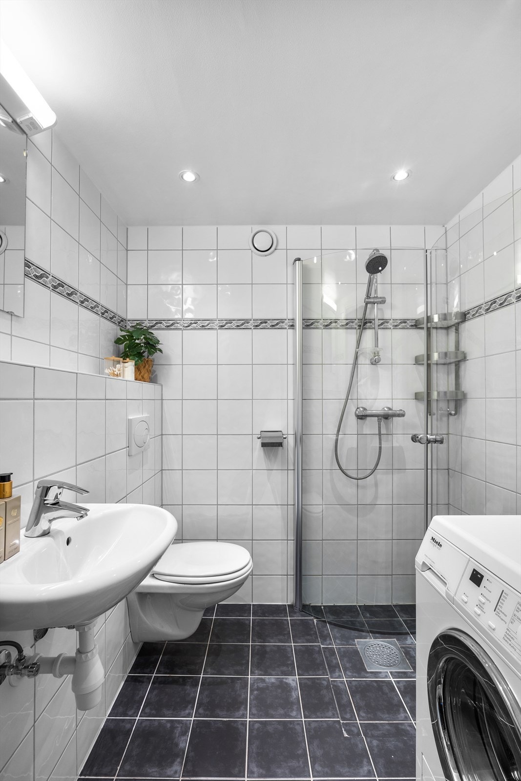 Det er også opplegg for vaskemaskin. Badet fremstår som funksjonelt og praktisk innredet. Galleribilde