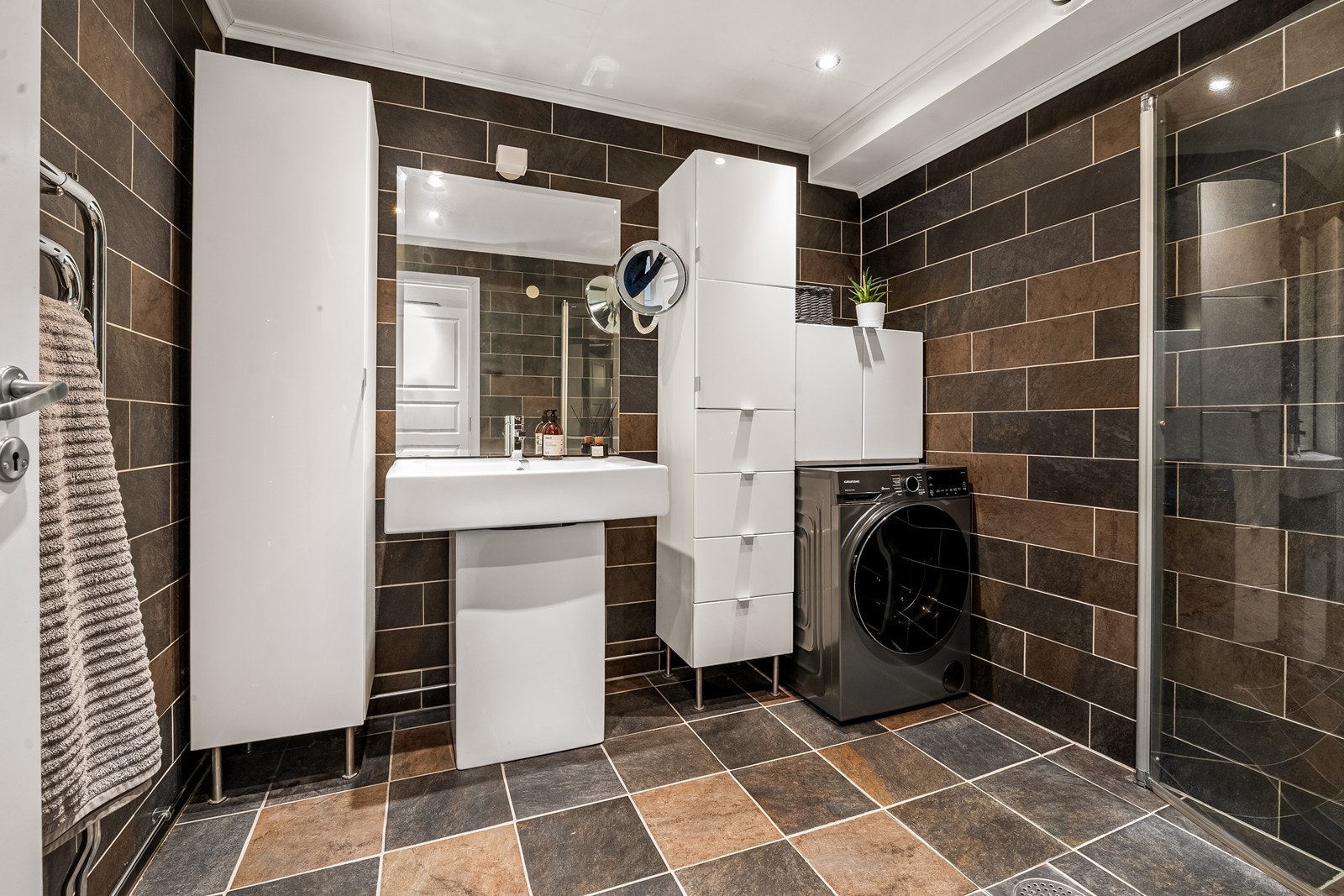 Badet har flislagte overflater, varmekabler og downlights, tidløs innredning og røropplegg for vaskemaskin. Galleribilde