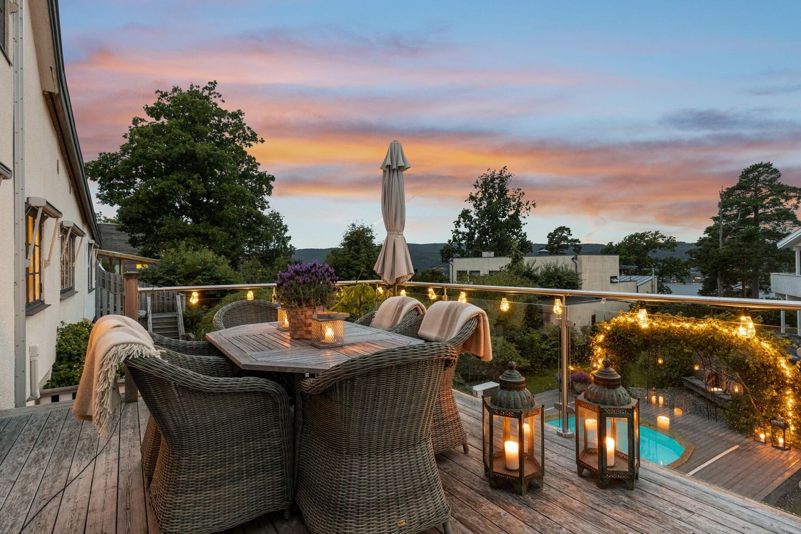 Solrik terrasse med adkomst fra stuen med utsikt og utsyn over hage og bassengområde. Galleribilde