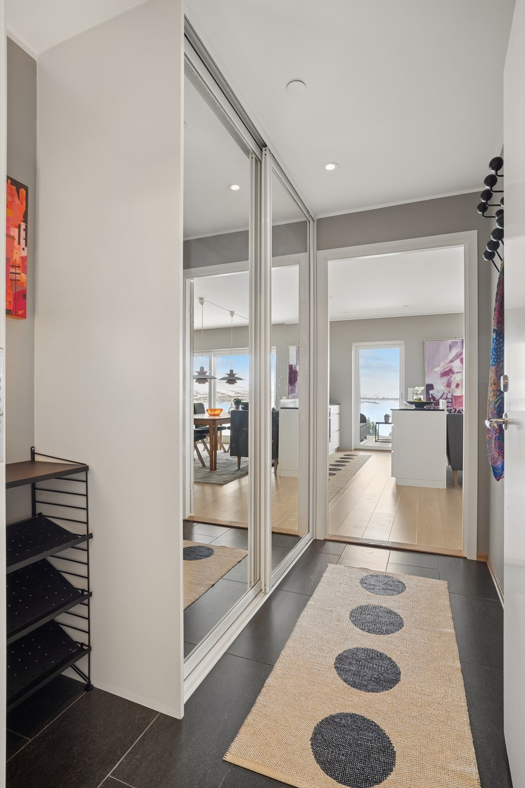 Romslig entré med stor skyvedørsgarderobe for oppbevaring av yttertøy. Galleribilde