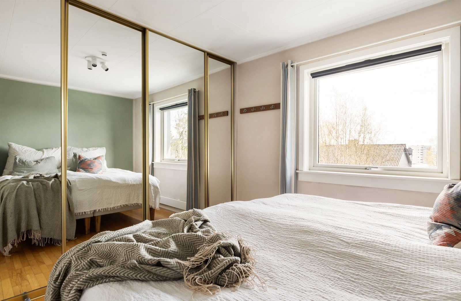 En stor skyvedørsgarderobe med speilfronter gir rikelig med oppbevaringsplass. Galleribilde