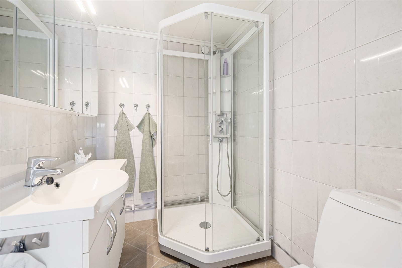 Badet i andre etasje har flislagte overflater, elektriske varmekabler i gulvet og dusjkabinett. Galleribilde