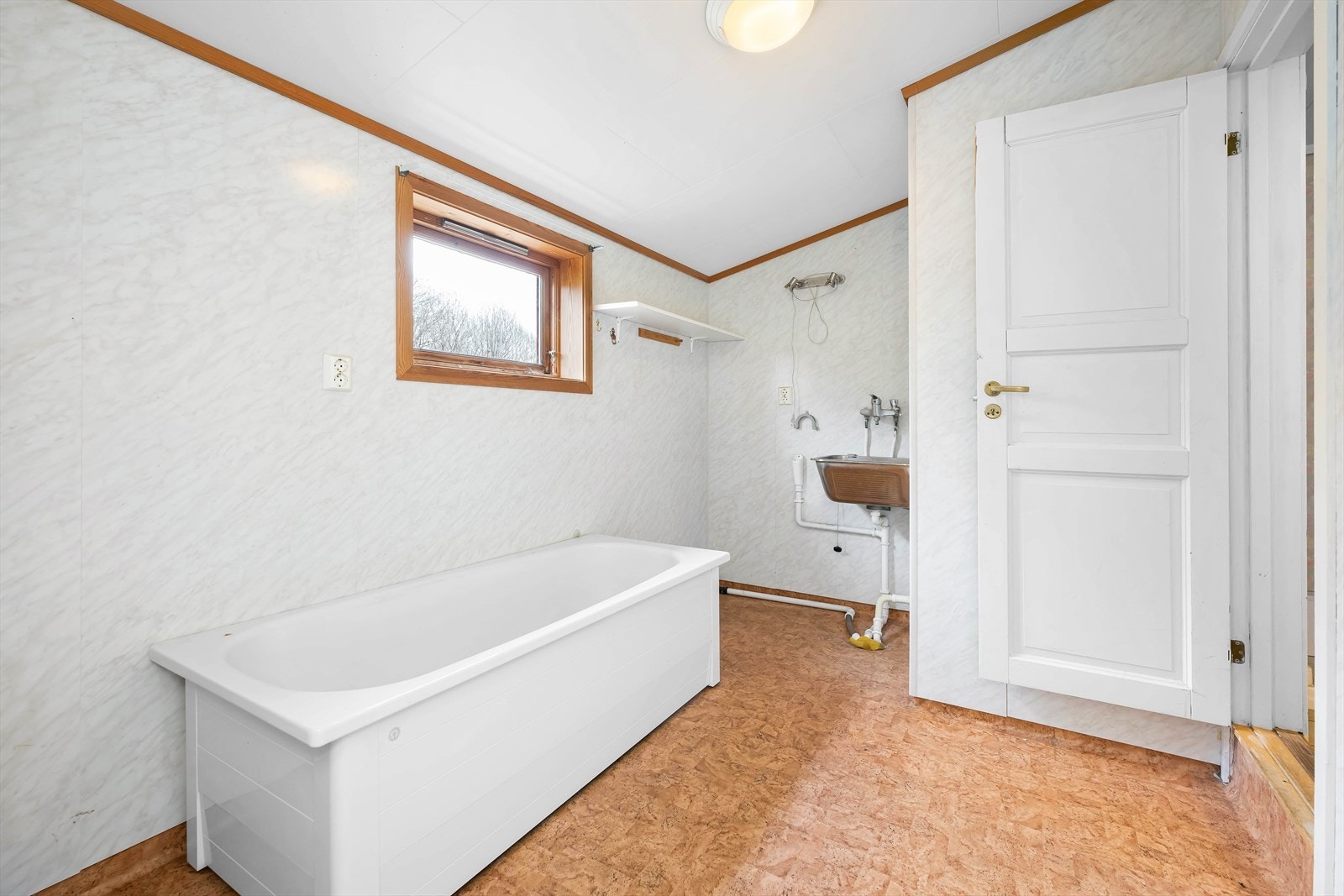 Badet er utstyrt med baderomsplater på veggene og belegg på gulv. Galleribilde