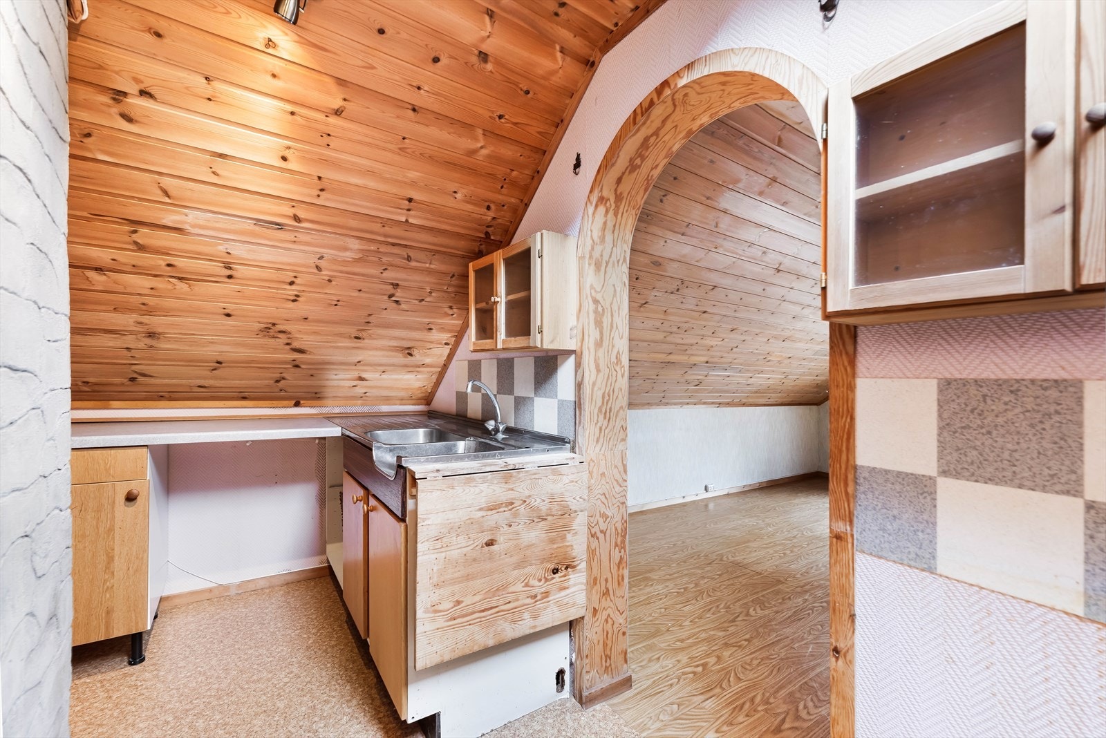 Loftskjøkkenet har en eldre innredning med laminert benkeplate. Galleribilde