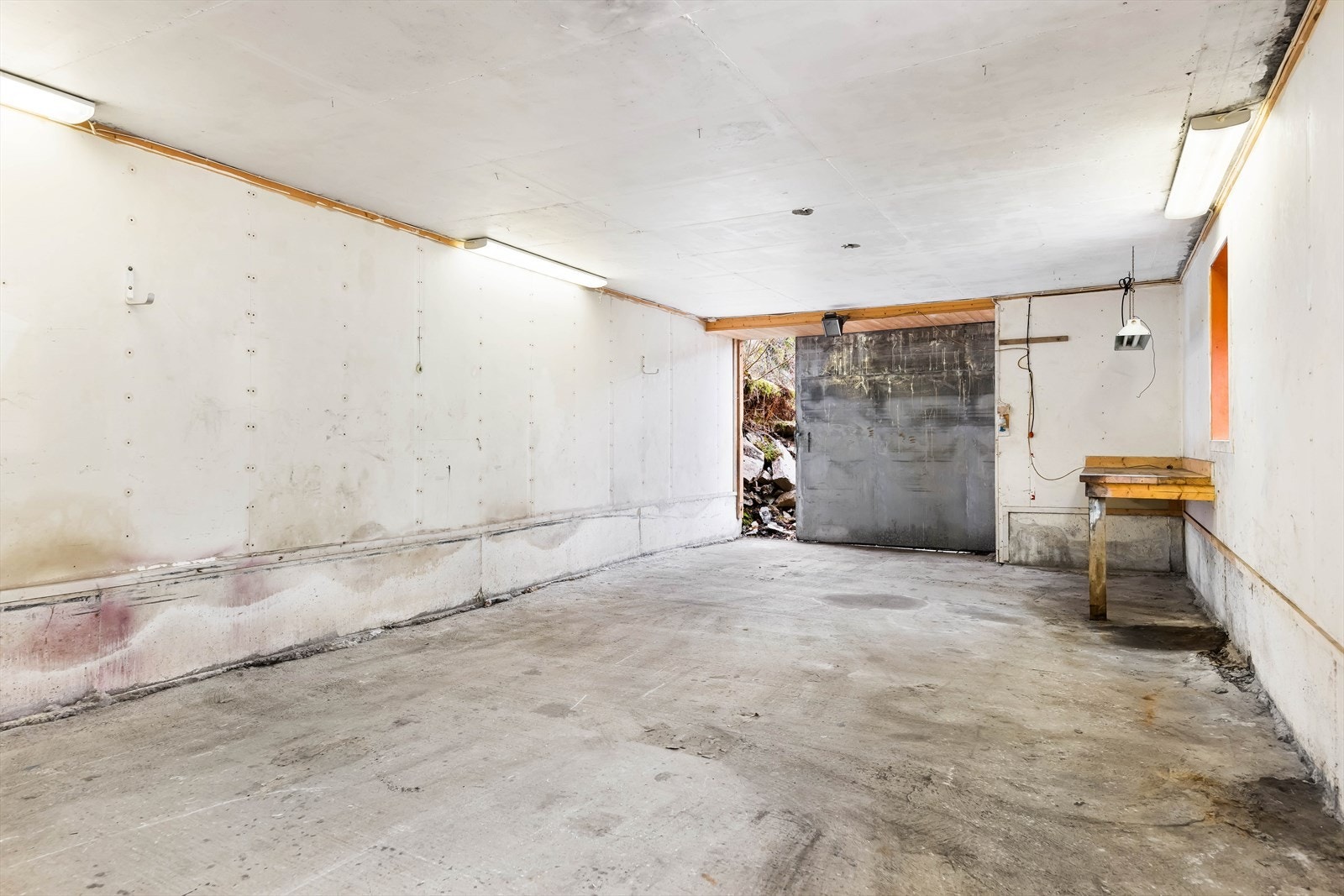 Rommet har betonggulv og vegger i trekonstruksjon, med god plass til parkering og lagring. Galleribilde