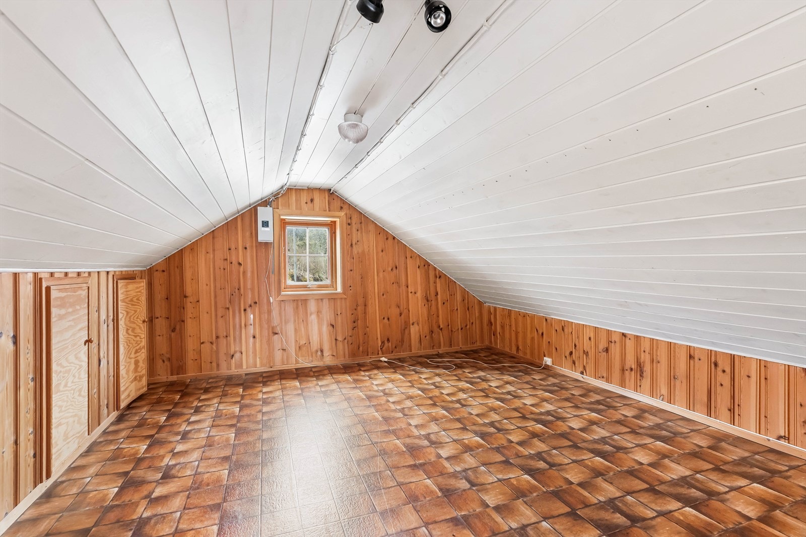 Soverom i loftsetasjen med panelvegger og gulvbelegg. Galleribilde